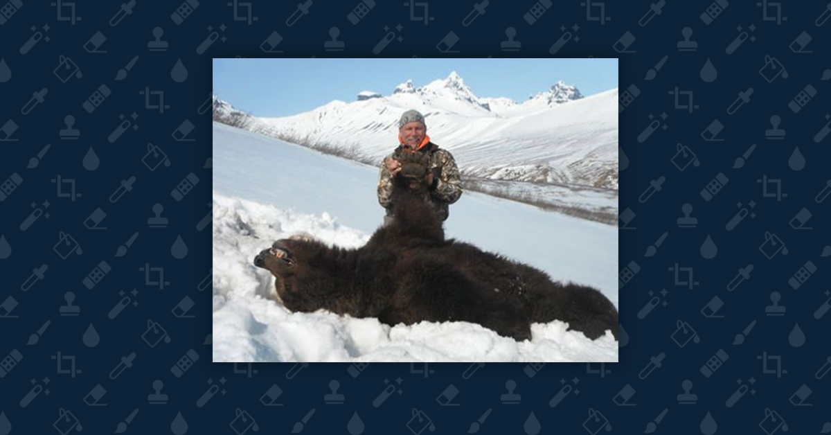Man posing with freshly killed bear