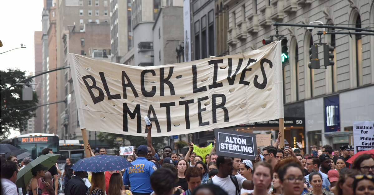 Crowd displaying a banner saying "Black Lives Matter"