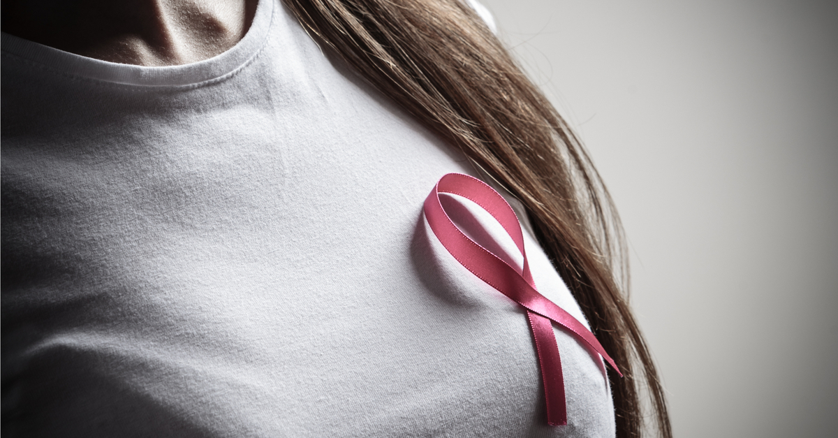 woman with pink ribbon pinned to shirt