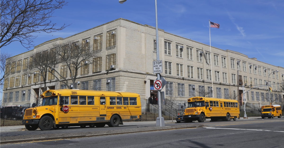 Outside shot of a public school in New York City, with buses parked outside