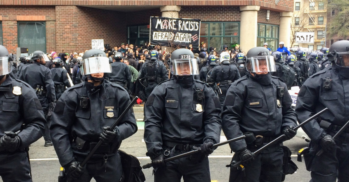 WASHINGTON, Jan. 20, 2017 -- Police in riot gear form a line around detained #DisruptJ20 protesters holding a "Make Racists Afraid Again" banner during the presidential inauguration of Donald Trump.