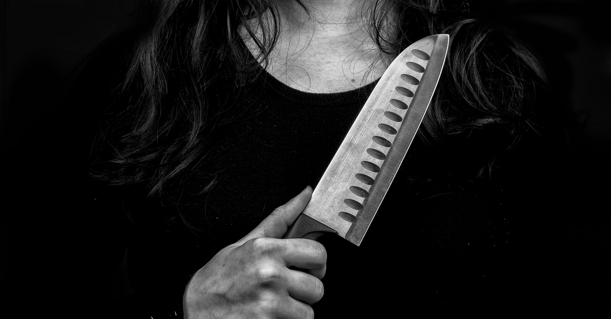 Black and white photograph of a woman holding a knife