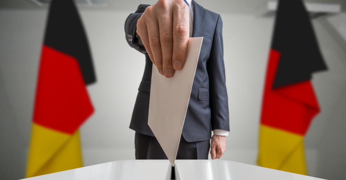 Voter dropping ballot into box with German flags on either side