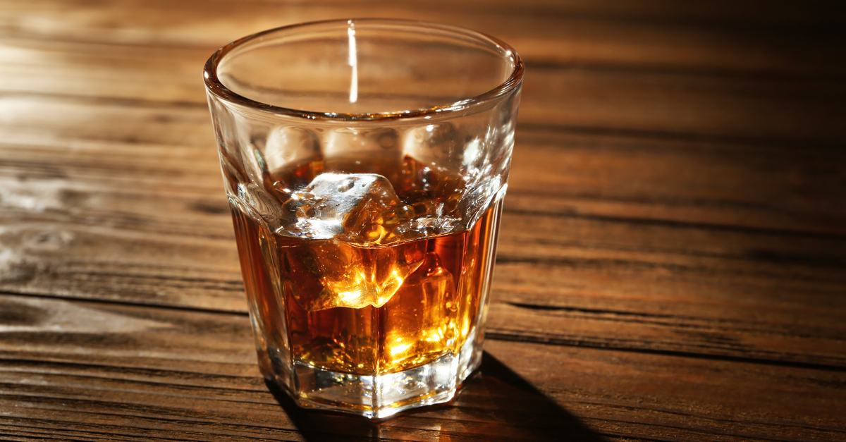 glass of whisky on wooden table