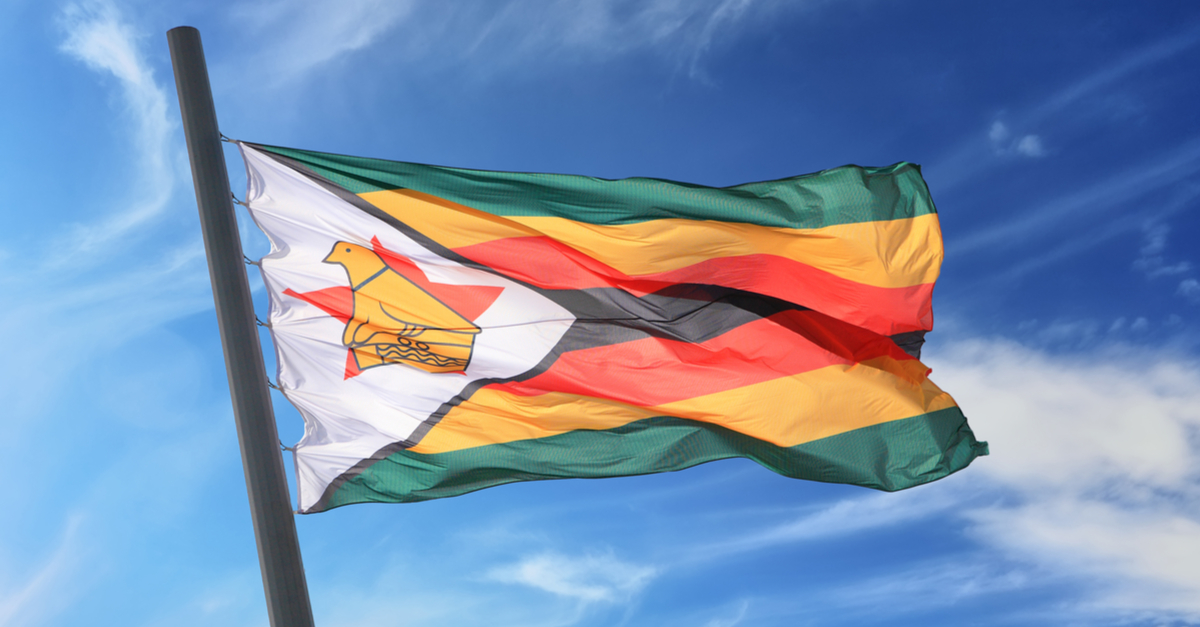 Zimbabwe's flag waving against a blue sky