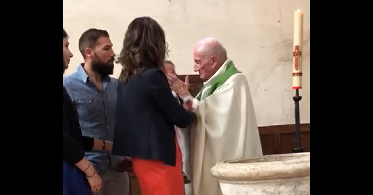 Screen shot from video of a priest in France slapping a baby.
