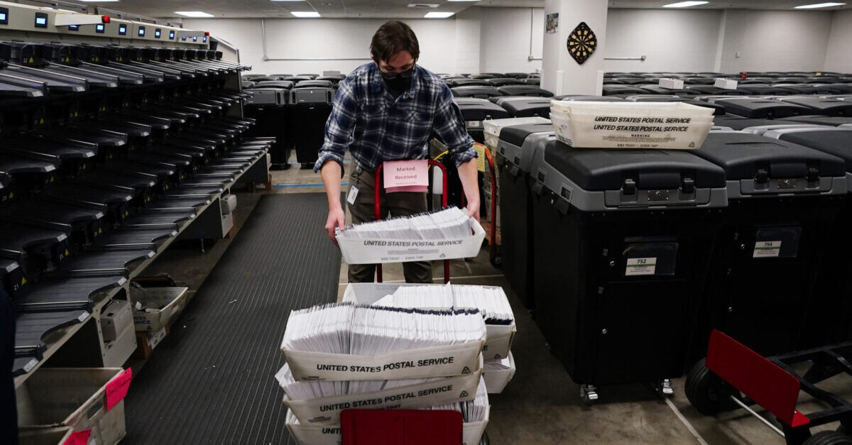 Michael Imms, with Chester County Voter Services, gathers mail-in ballots after being sorted for the 2020 General Election in the United States, Friday, Oct. 23, 2020, in West Chester, Pa. (AP Photo/Matt Slocum)