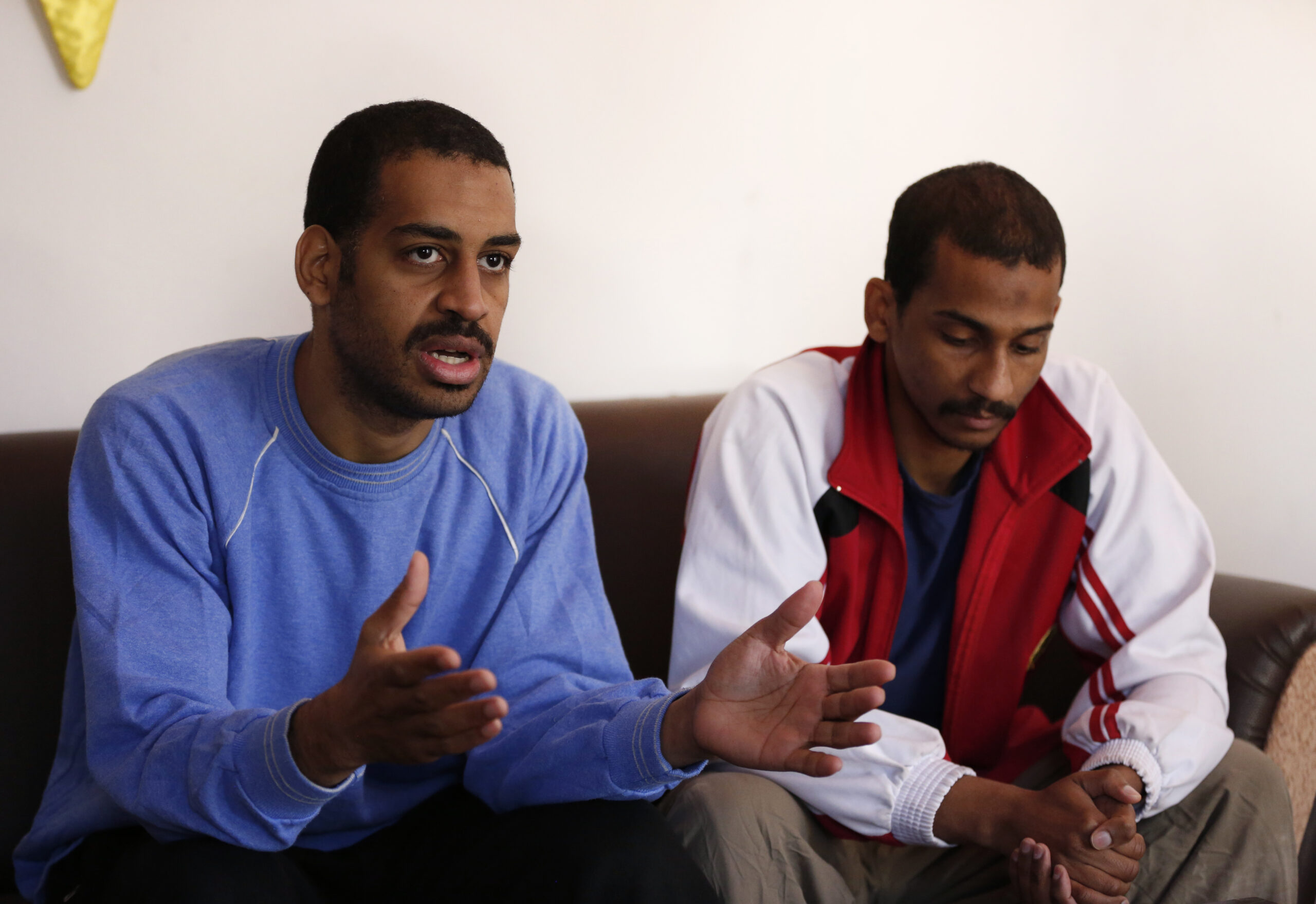 FILE - In this March 30, 2019, file photo, Alexanda Amon Kotey, left, and El Shafee Elsheikh, who were allegedly among four British jihadis who made up a brutal Islamic State cell dubbed "The Beatles," speak during an interview with The Associated Press at a security center in Kobani, Syria. The Justice Department is preparing to announce charges Wednesday against two men from Britain who joined the Islamic State and were part of a cell that beheaded Western hostages, a law enforcement official said. Their arrival in the U.S. to face charges sets the stage for arguably the most sensational terrorism prosecution since the 2014 case against the suspected ringleader of a deadly attack on the diplomatic compound in Benghazi, Libya.(AP Photo/Hussein Malla, File)
