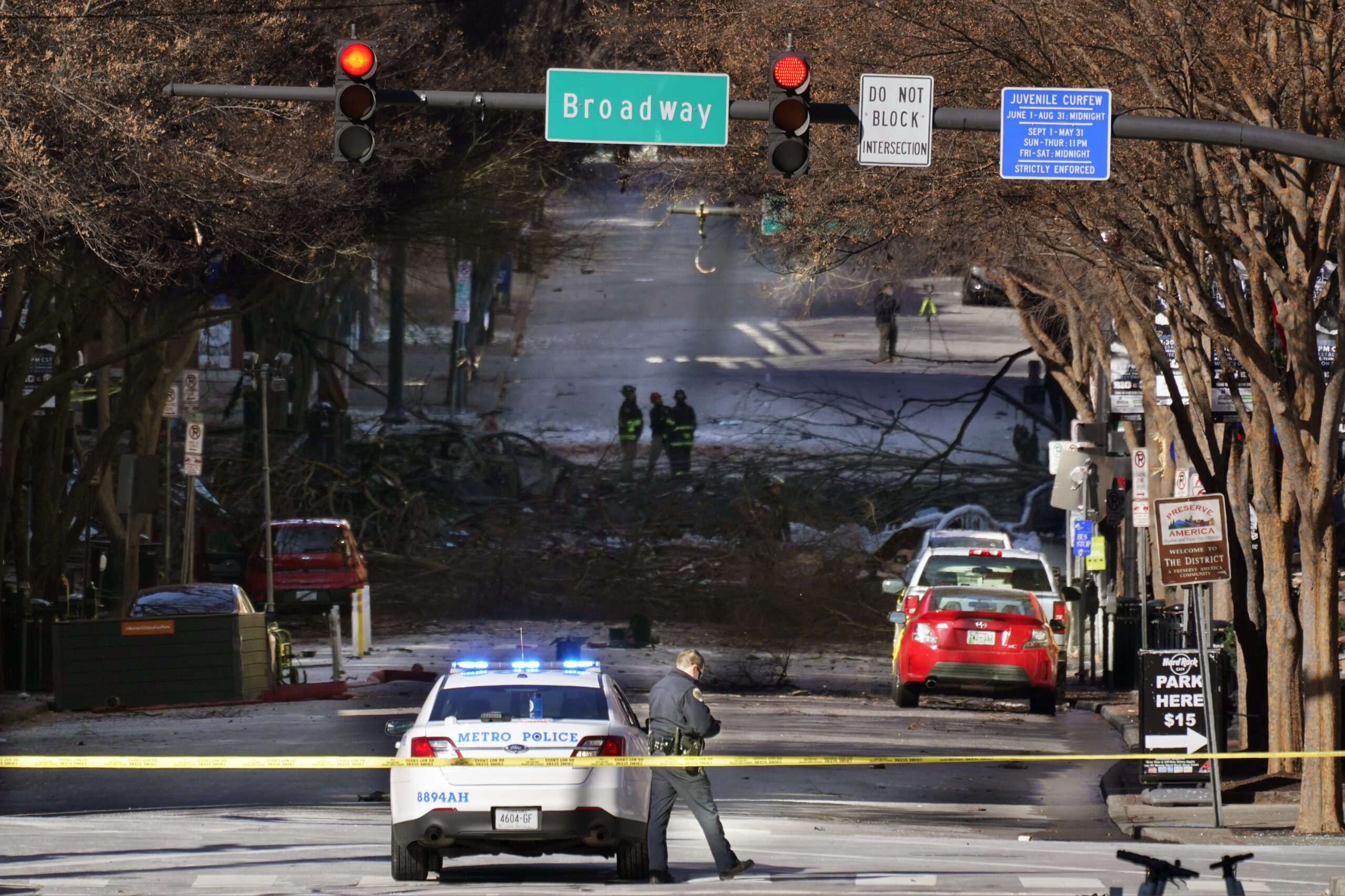 A Nashville Police officer blocks the entrance to the scene of an explosion Saturday, Dec. 26, 2020, in Nashville, Tenn. The explosion that shook the largely deserted streets of downtown Nashville early Christmas morning shattered windows, damaged buildings and wounded three people. Authorities said they believed the blast was intentional. (AP Photo/Mark Humphrey)