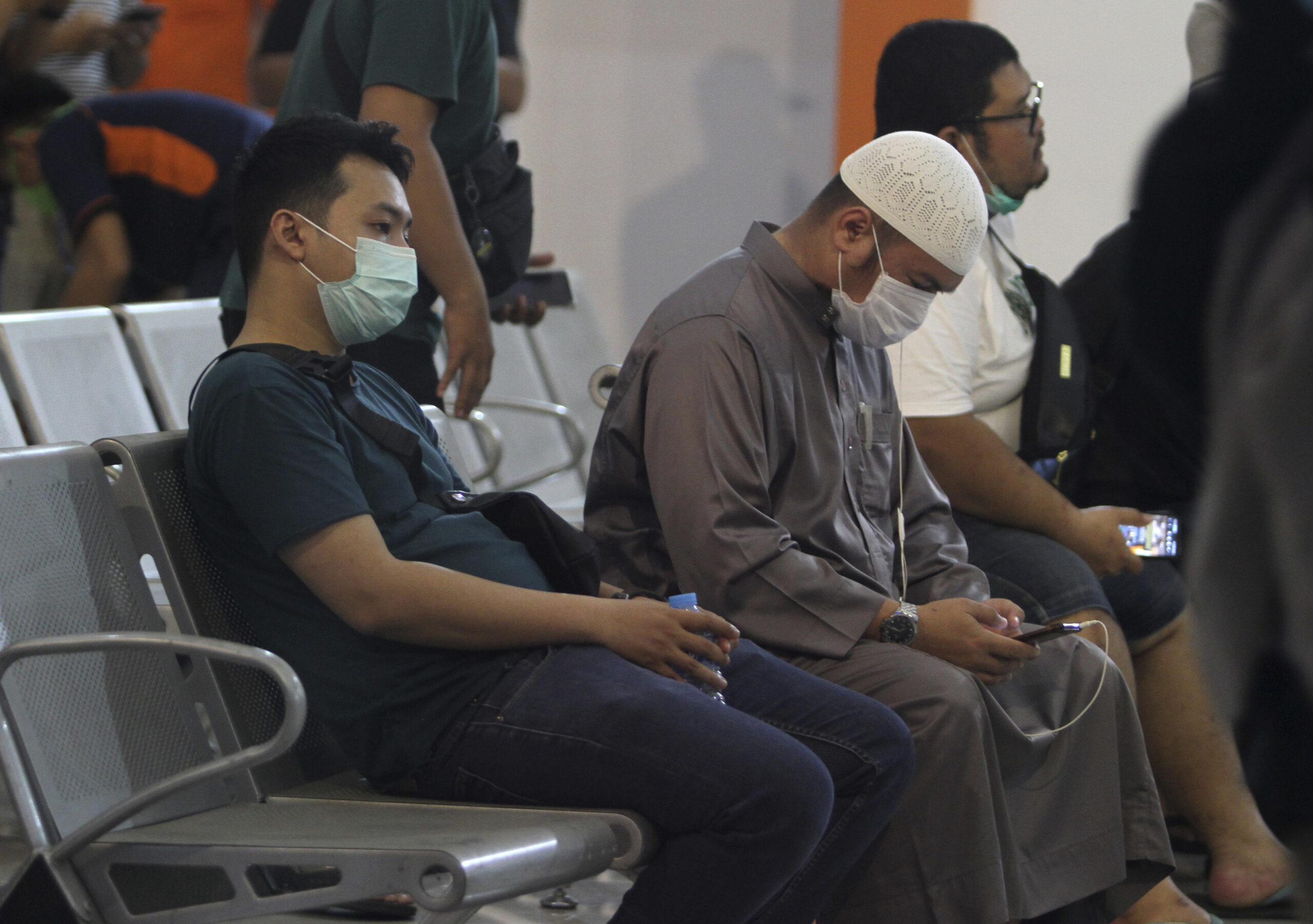 People wait for news on their relatives who are on board of Sriwijaya Air passenger jet that lost contact with air traffic controllers after take off, at Soepadio International Airport in Pontianak, West Kalimantan, Indonesia, Saturday, Jan. 9, 2021. A Sriwijaya Air passenger jet with 56 passengers and six crew members onboard, lost contact with air traffic controllers after taking off from Indonesia's capital on Saturday on a domestic flight, officials said. (AP Photo/Helmansyah)