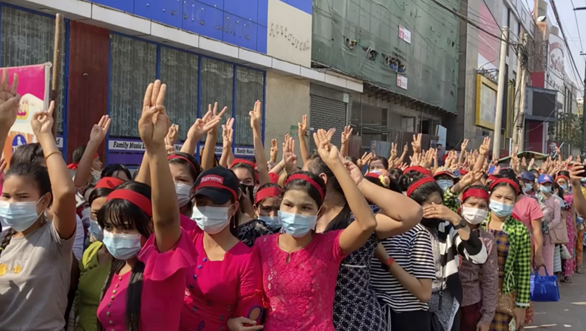 In this image made from video, protesters flash the three-fingered salute while they gather to march Saturday, Feb. 6, 2021, in Yangon, Myanmar. Myanmar’s new military authorities appeared to have cut most access to the Internet on Saturday as they faced a rising tide of protest over their coup that toppled Aung San Suu Kyi's elected civilian government.(AP Photo)