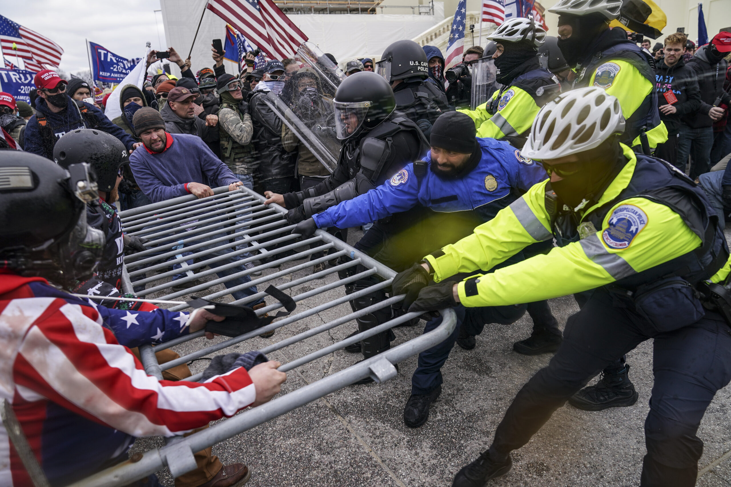 FILE - In this Jan. 6, 2021, file photo a violent mob of Trump supporters try to break through a police barrier at the Capitol in Washington. Violent extremists motivated by political grievances and racial biases pose an “elevated threat” to the U.S. homeland, officials said Wednesday, March 17, in a unclassified intelligence report released more than two months after a violent mob of insurrectionists stormed the U.S. Capitol. (AP Photo/John Minchillo File)