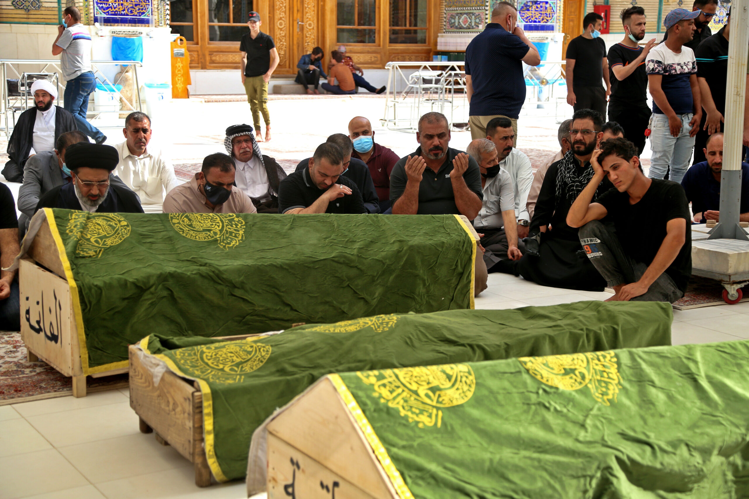 Mourners pray near the coffins of coronavirus patients who were killed in a hospital fire, during their funeral at the Imam Ali shrine in Najaf, Iraq, Sunday, April 25, 2021. Iraq’s Interior Ministry said Sunday that over 80 people died and over 100 were injured in a catastrophic fire that broke out in the intensive care unit of a Baghdad hospital tending to severe coronavirus patients in the early morning Sunday. (AP Photo/Anmar Khalil)