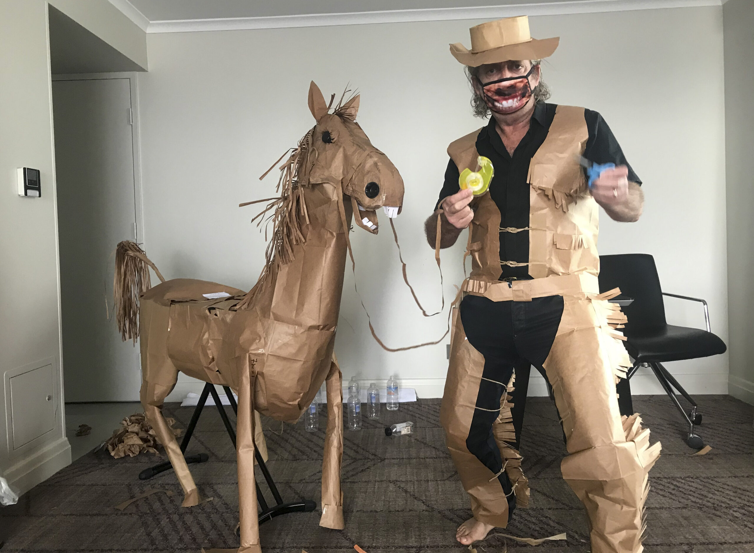 CORRECTS NAME - David Marriott poses with his paper horse "Russell" in his hotel room in Brisbane, Australia, April 1, 2021. While in quarantine inside his Brisbane hotel room, the art director was bored and started making a cowboy outfit from the paper bags his meals were being delivered in. His project expanded to include a horse and a clingfilm villain that he has daily adventures with, in images that have gained a huge online following. (David Marriott via AP)