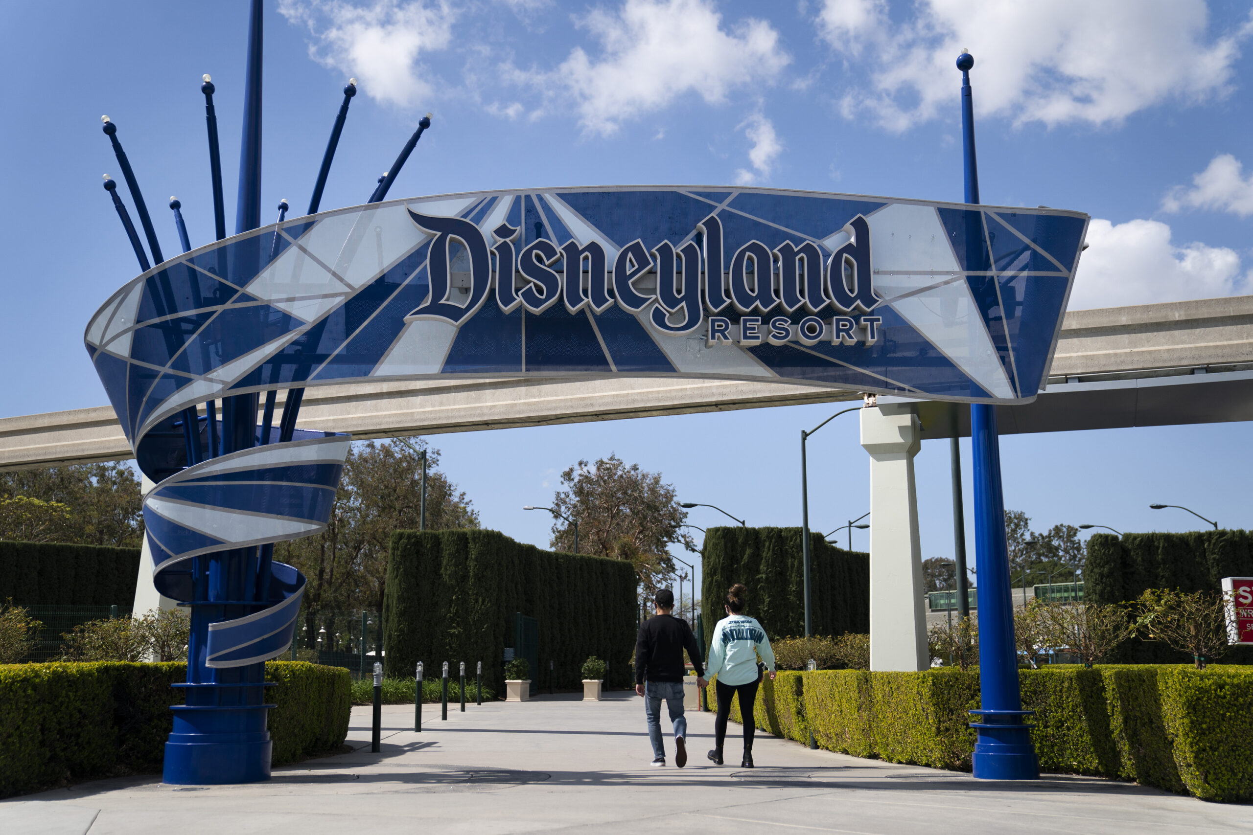 FILE - Two visitors enter Disneyland Resort in Anaheim, Calif., on March 9, 2021. Disneyland said Thursday, April 8, 2021, that its new Avengers Campus will debut on June 4, nearly a year after originally planned. (AP Photo/Jae C. Hong)