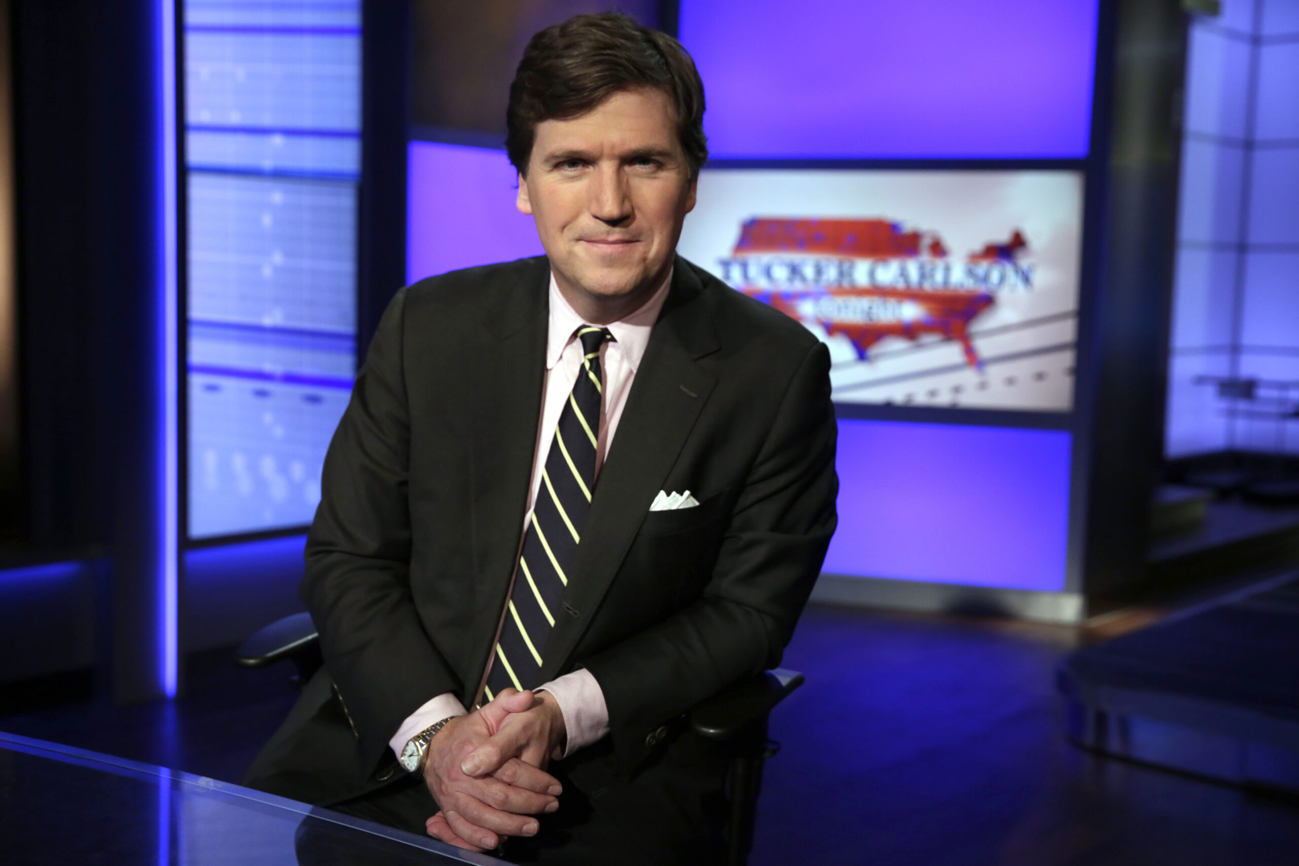 FILE - In this Thursday, March 2, 2107 file photo, Tucker Carlson, host of "Tucker Carlson Tonight," poses for a photo in a Fox News Channel studio in New York. The Anti-Defamation League has called for Fox News to fire prime-time opinion host Tucker Carlson because he defended a white-supremacist theory that says whites are being “replaced” by people of color. In a letter to Fox News CEO Suzanne Scott on Friday, April 9, 2021the head of the ADL, Jonathan Greenblatt, said Carlson's “rhetoric was not just a dog whistle to racists — it was a bullhorn.” (AP Photo/Richard Drew, File)