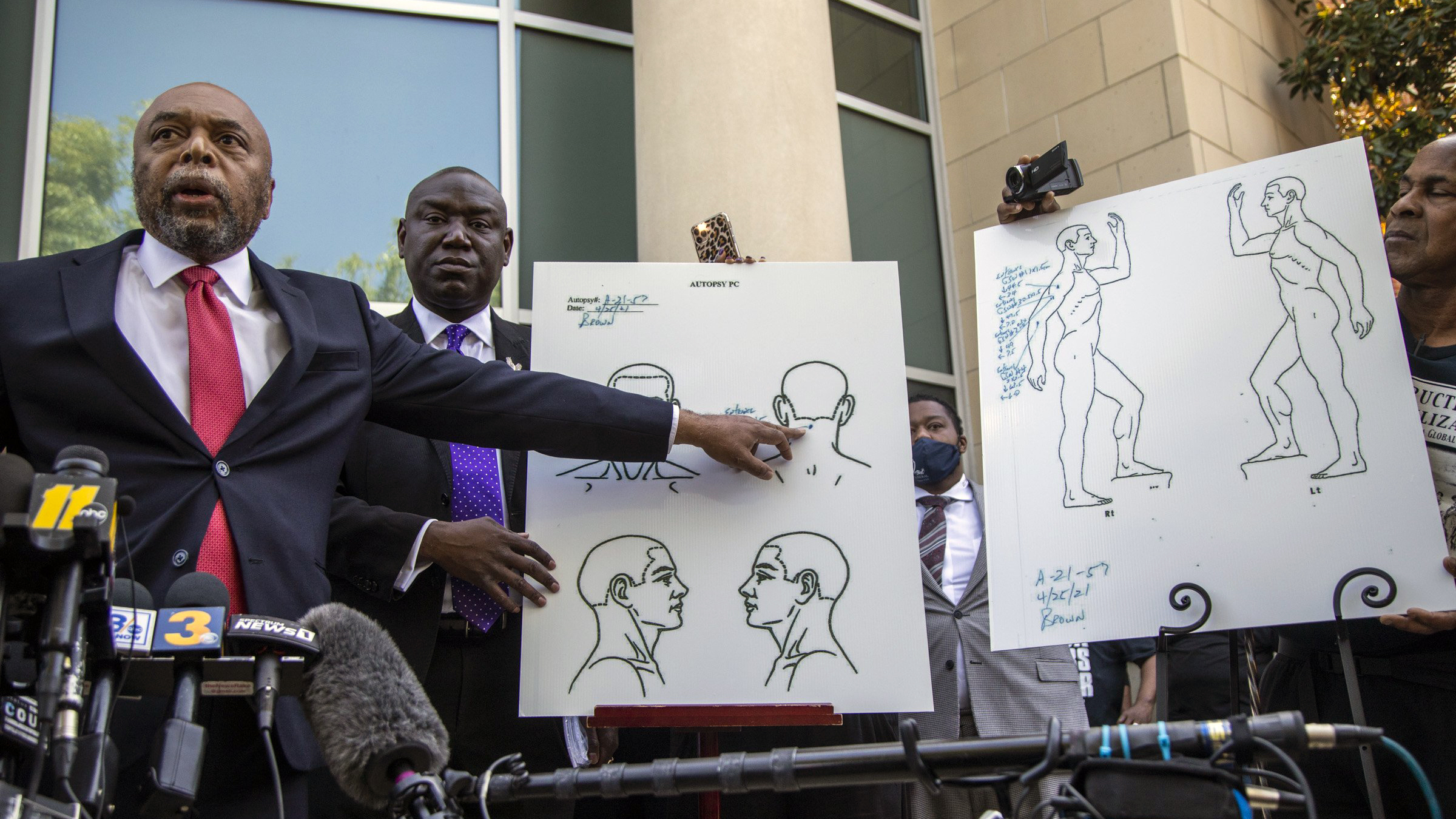 Attorneys for the family of Andrew Brown Jr., Wayne Kendall, left, and Ben Crump hold a news conference Tuesday, April 27, 2021 outside the Pasquotank County Public safety building in Elizabeth City, N.C., to announce results of the autopsy they commissioned. The attorneys say an independent autopsy shows that Brown, a Black man, was shot five times, including in the back of the head. Brown was shot Wednesday by deputies serving drug-related search and arrest warrant. (Travis Long/The News & Observer via AP)