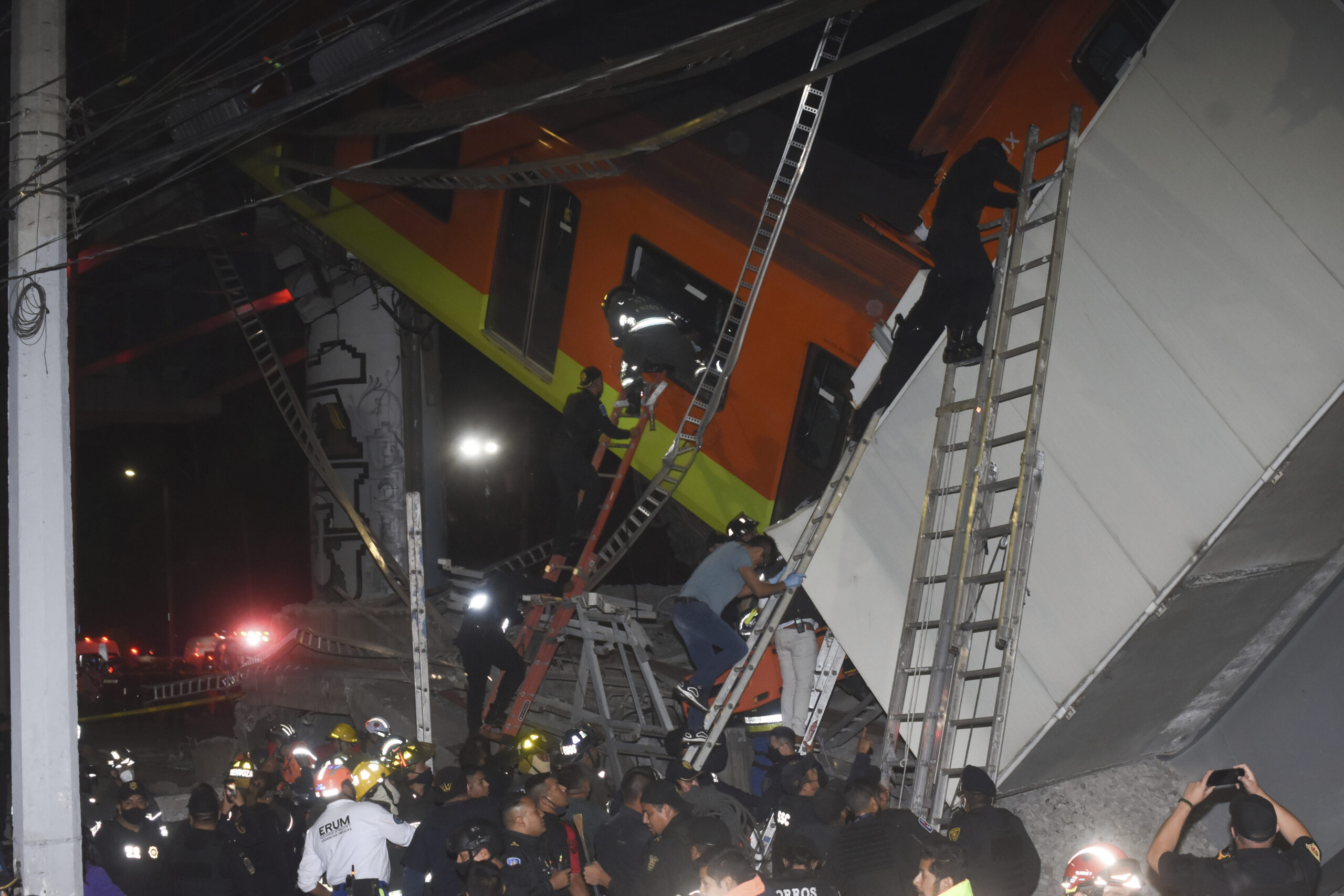 Mexico City fire fighters and rescue personnel work to recover victims from a subway accident after a section of Line 12 of the subway collapsed in Mexico City, Monday, May 3, 2021. The section passing over a road in southern Mexico City collapsed Monday night, dropping a subway train, trapping cars and causing at least 50 injuries and several dead, authorities said. (AP Photo/Jose Ruiz)