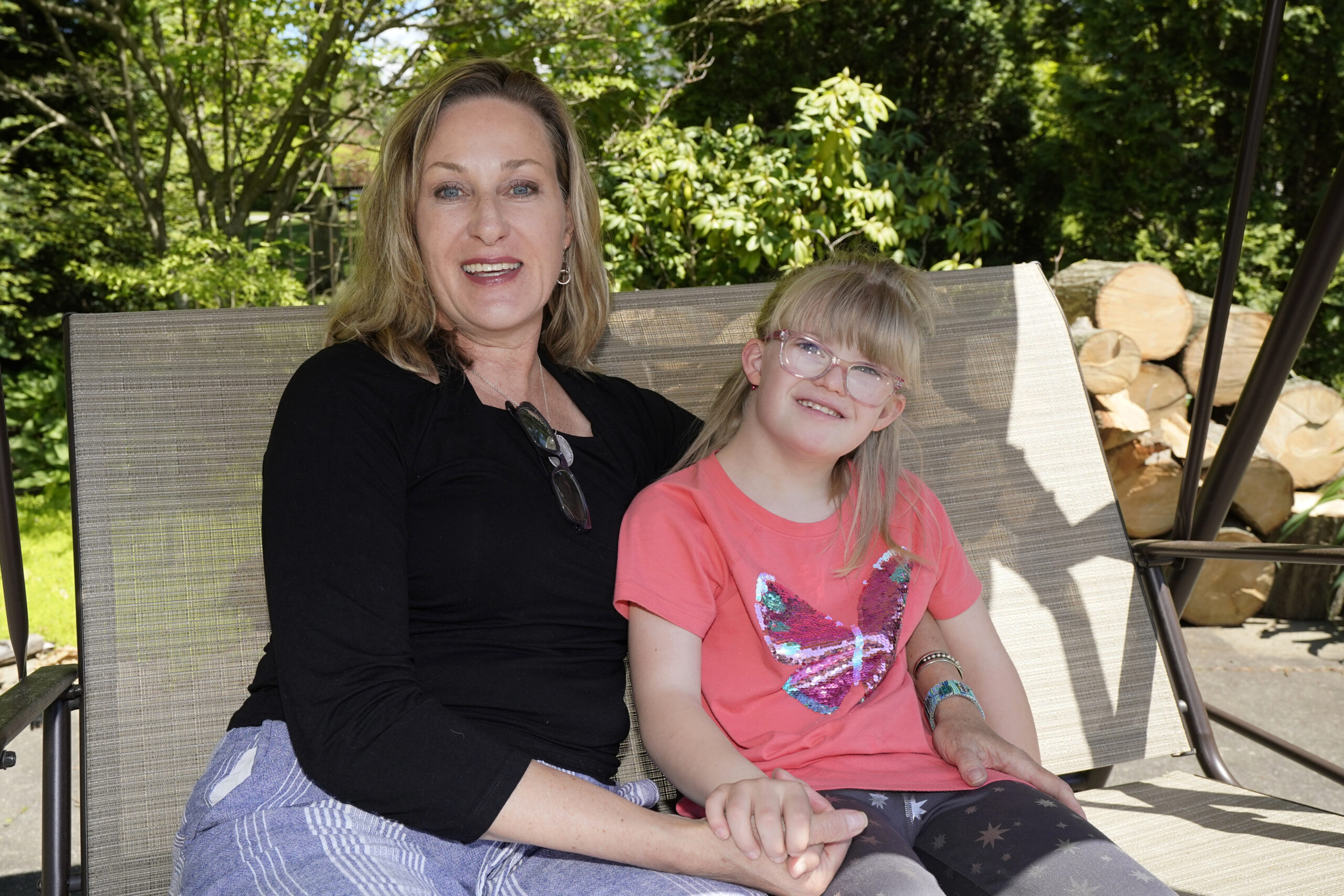 Holly Christensen, left, sits in a swing with her daughter, Lyra, Thursday, May 13, 2021, in Akron, Ohio. Anti-abortion activists say 2021 has been a breakthrough year for legislation in several states seeking to prohibit abortions based on a prenatal diagnosis of Down syndrome. Opponents of the bills, including some parents with children who have Down syndrome like Holly, argue that elected officials should not be meddling with a woman’s deeply personal decision on whether to carry a pregnancy to term after a Down syndrome diagnosis. (AP Photo/Tony Dejak)