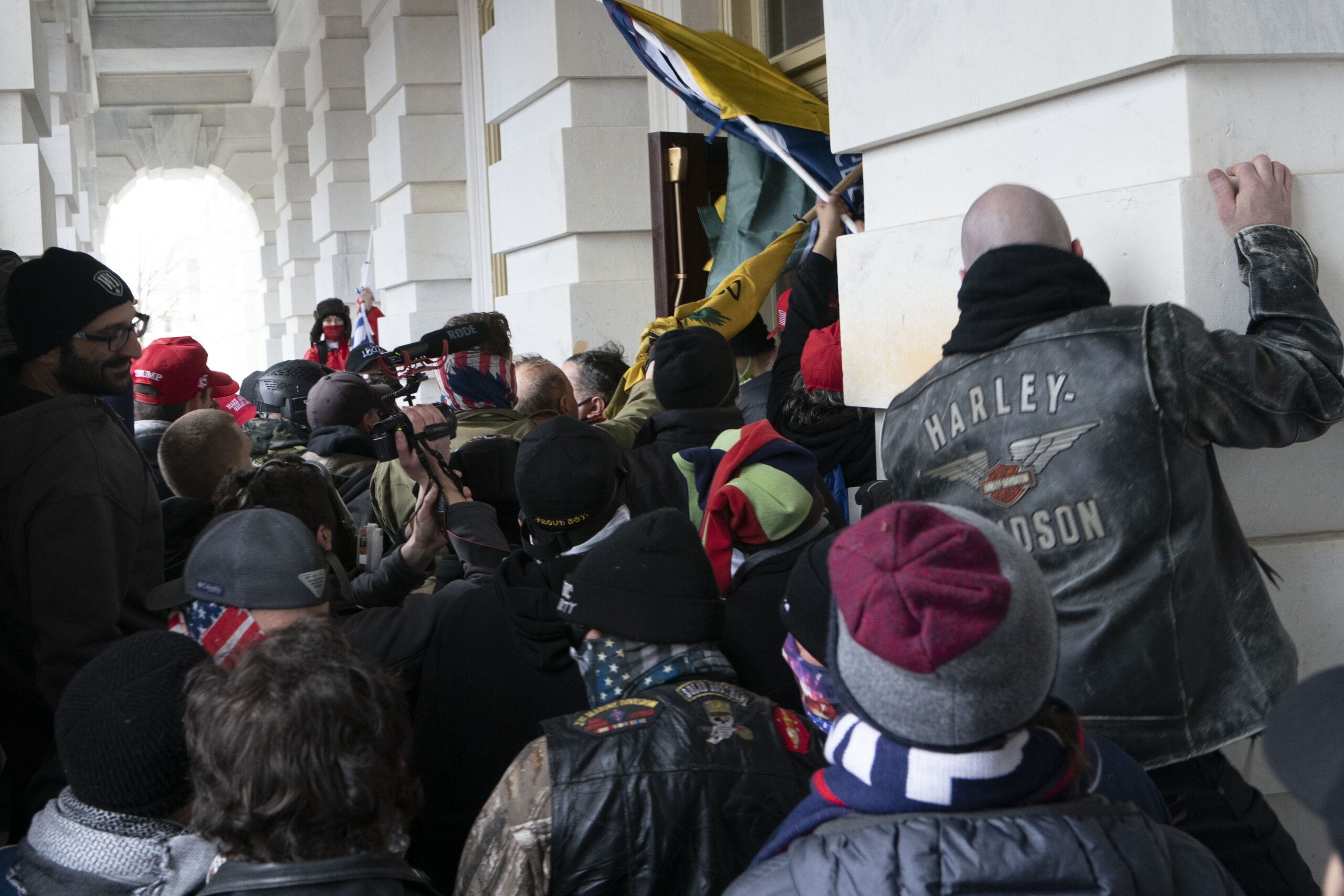 FILE - In this Jan. 6, 2021 file photo insurrectionists loyal to President Donald Trump try to open a door of the U.S. Capitol as they riot in Washington. At least a dozen of the 400 people charged so far in the Jan. 6 insurrection have made dubious claims about their encounters with officers at the Capitol. The most frequent argument is that they can't be guilty of anything, because police stood by and welcomed them inside, even though the mob pushed past police barriers, sprayed chemical irritants and smashed windows as chaos enveloped the government complex. (AP Photo/Jose Luis Magana, File)