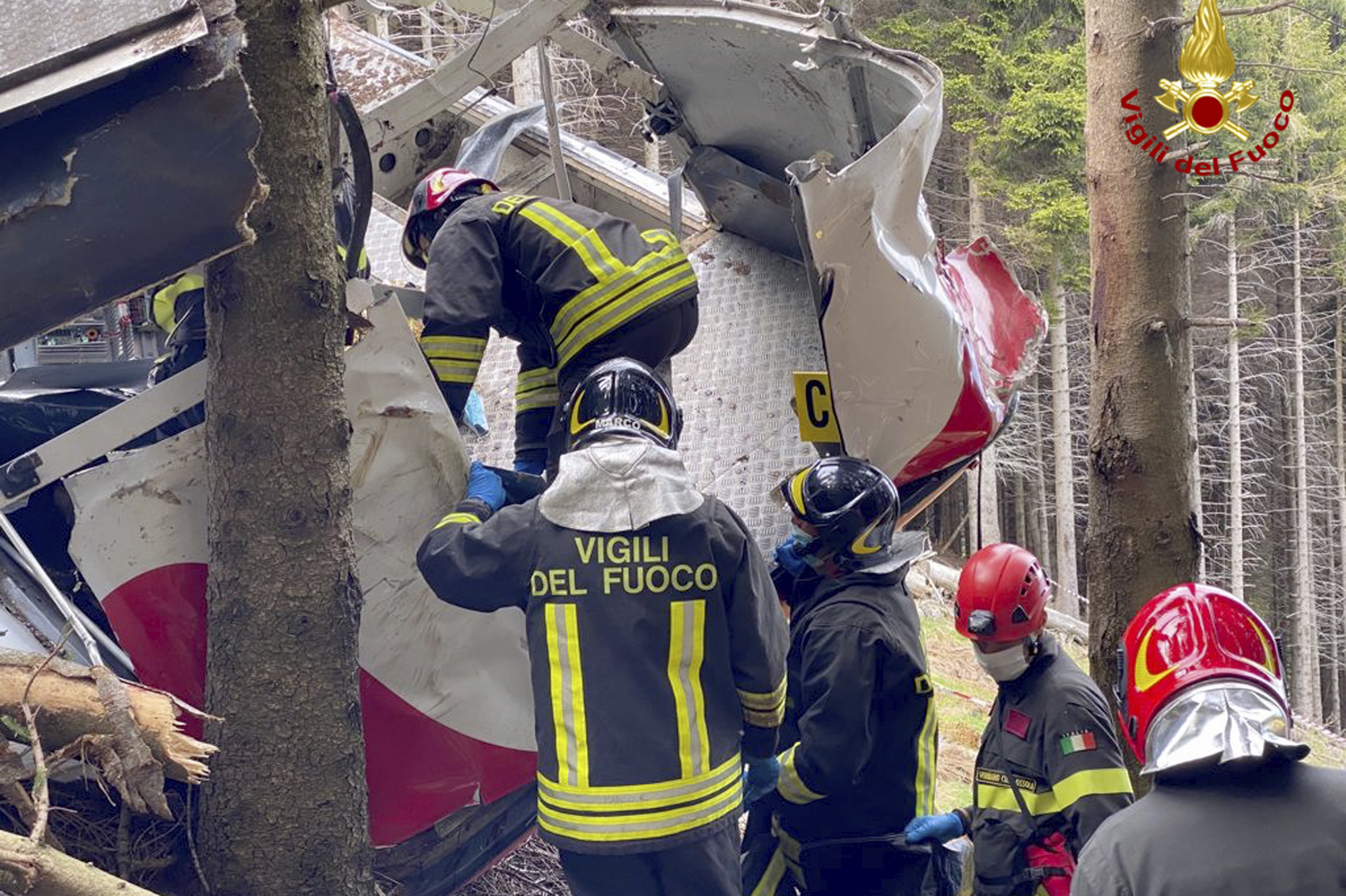 Rescuers work by the wreckage of a cable car after it collapsed near the summit of the Stresa-Mottarone line in the Piedmont region, northern Italy, Sunday, May 23, 2021. Italy’s transport minister was heading Monday, May 24, 2021 to the scene of a cable car disaster that killed 14 people when the lead cable apparently snapped and the cabin careened back down the mountain until it pulled off the line and crashed to the ground. (Vigili del Fuoco Firefighters via AP)