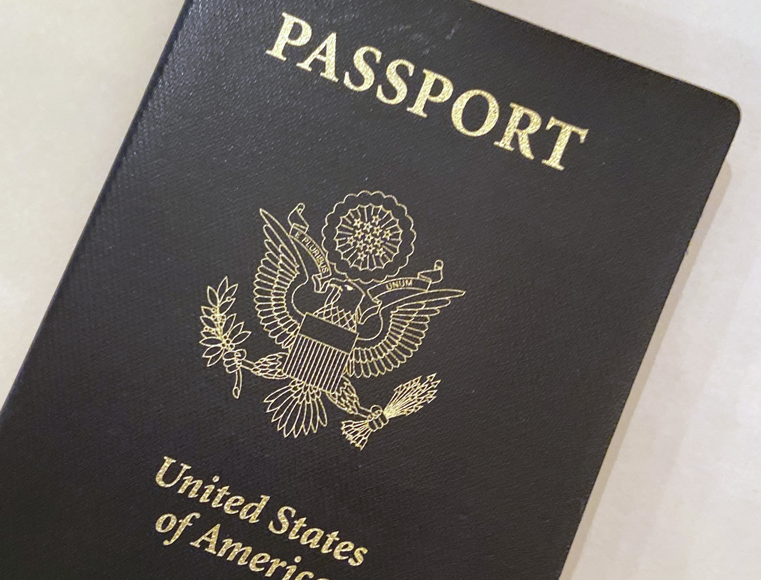This May 25, 2021 photo shows a U.S. Passport cover in Washington. The Biden administration says American citizens holding recently expired U.S. passports will be allowed to return home from abroad on that document until the end of year. (AP Photo/Eileen Putman)