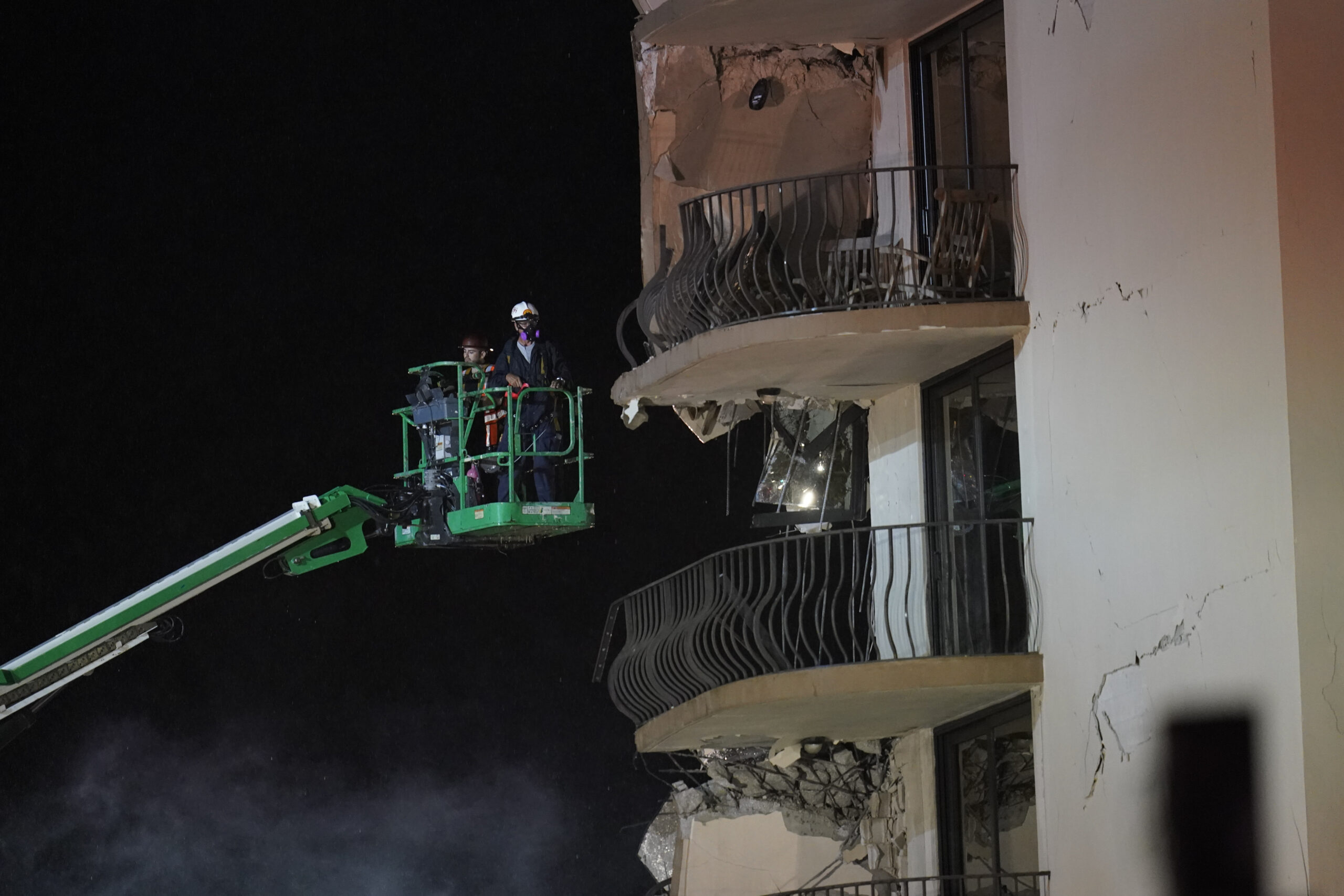 Workers use a lift to investigate balconies in the still-standing portion of the building, as rescue efforts continue where a wing of a 12-story beachfront condo building collapsed, late on Thursday, June 24, 2021, in the Surfside area of Miami.(AP Photo/Gerald Herbert)