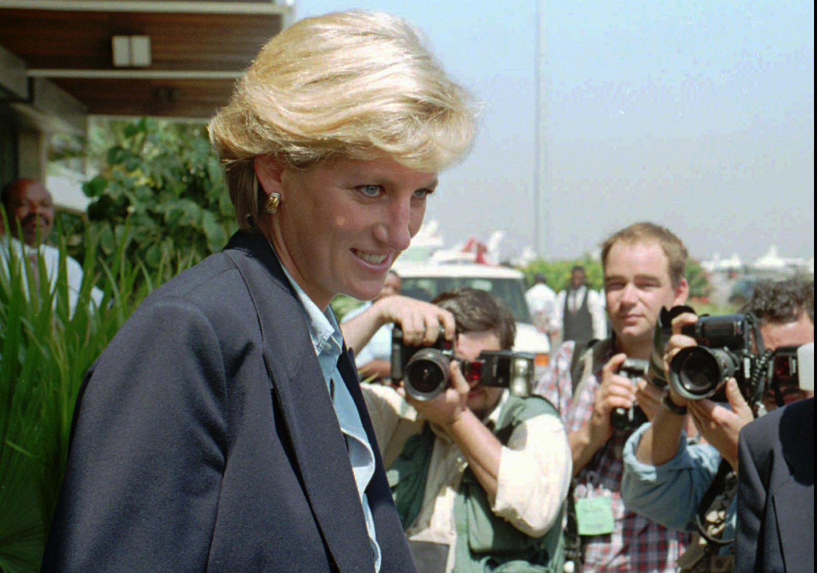 CORRECTING YEAR TO 1997 - FILE - In this Thursday, Jan. 16, 1997 file photo, Britain's Princess Diana faces photographers as she leaves Luanda airport building to board a plane to Johannesburg at the end of her four-day visit to Angola. For someone who began her life in the spotlight as “Shy Di,” Princess Diana became an unlikely, revolutionary during her years in the House of Windsor. She helped modernize the monarchy by making it more personal, changing the way the royal family related to people. By interacting more intimately with the public -- kneeling to the level of children, sitting on edge of a patient’s hospital bed, writing personal notes to her fans -- she set an example that has been followed by other royals as the monarchy worked to become more human and remain relevant in the 21st century. (AP Photo/Giovanni Deffidenti, File)