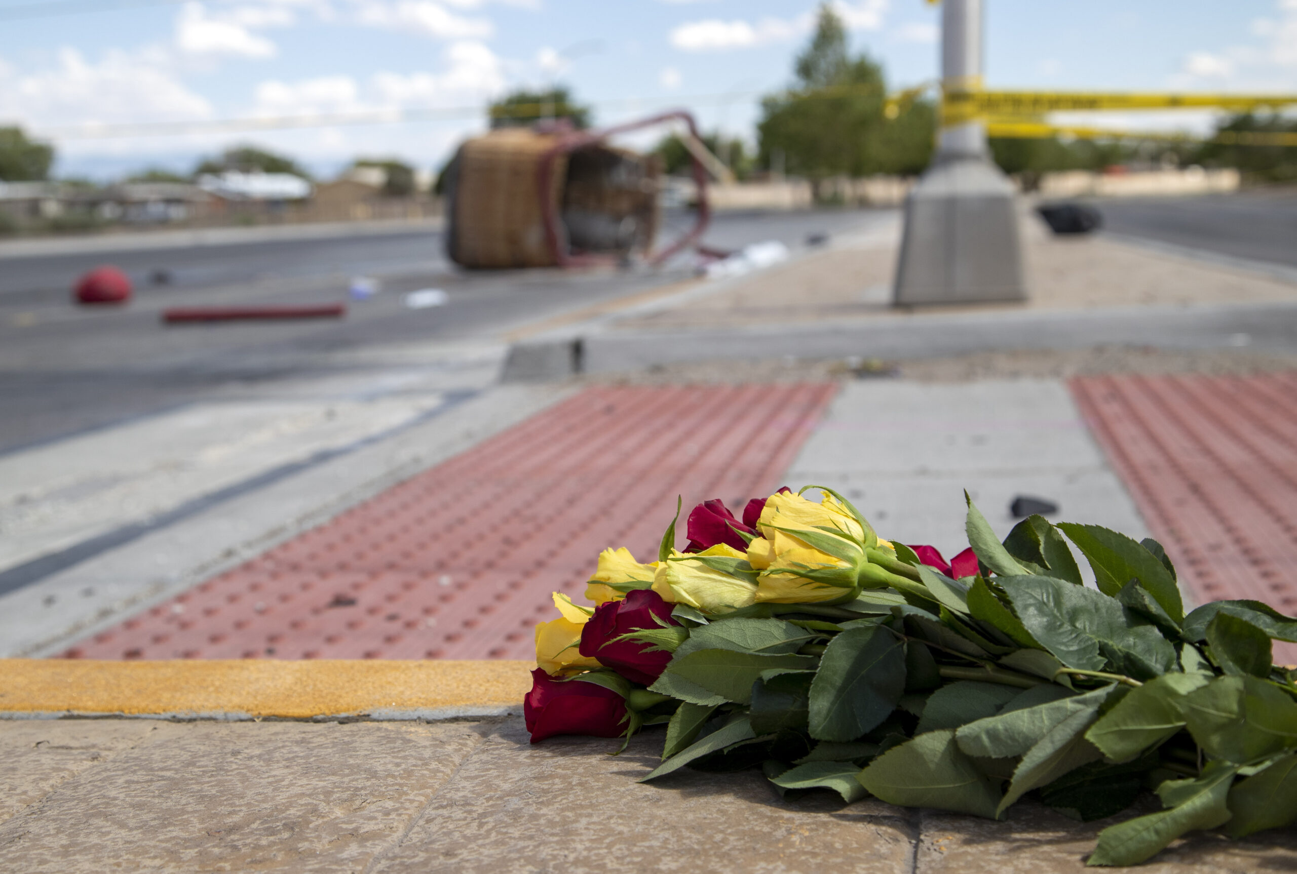A bouquet of flowers from a mourner is placed near the basket of a hot air balloon which crashed in Albuquerque, N.M., Saturday, June 26, 2021. Police said the five occupants died after it crashed on the busy street. (AP Photo/Andres Leighton)