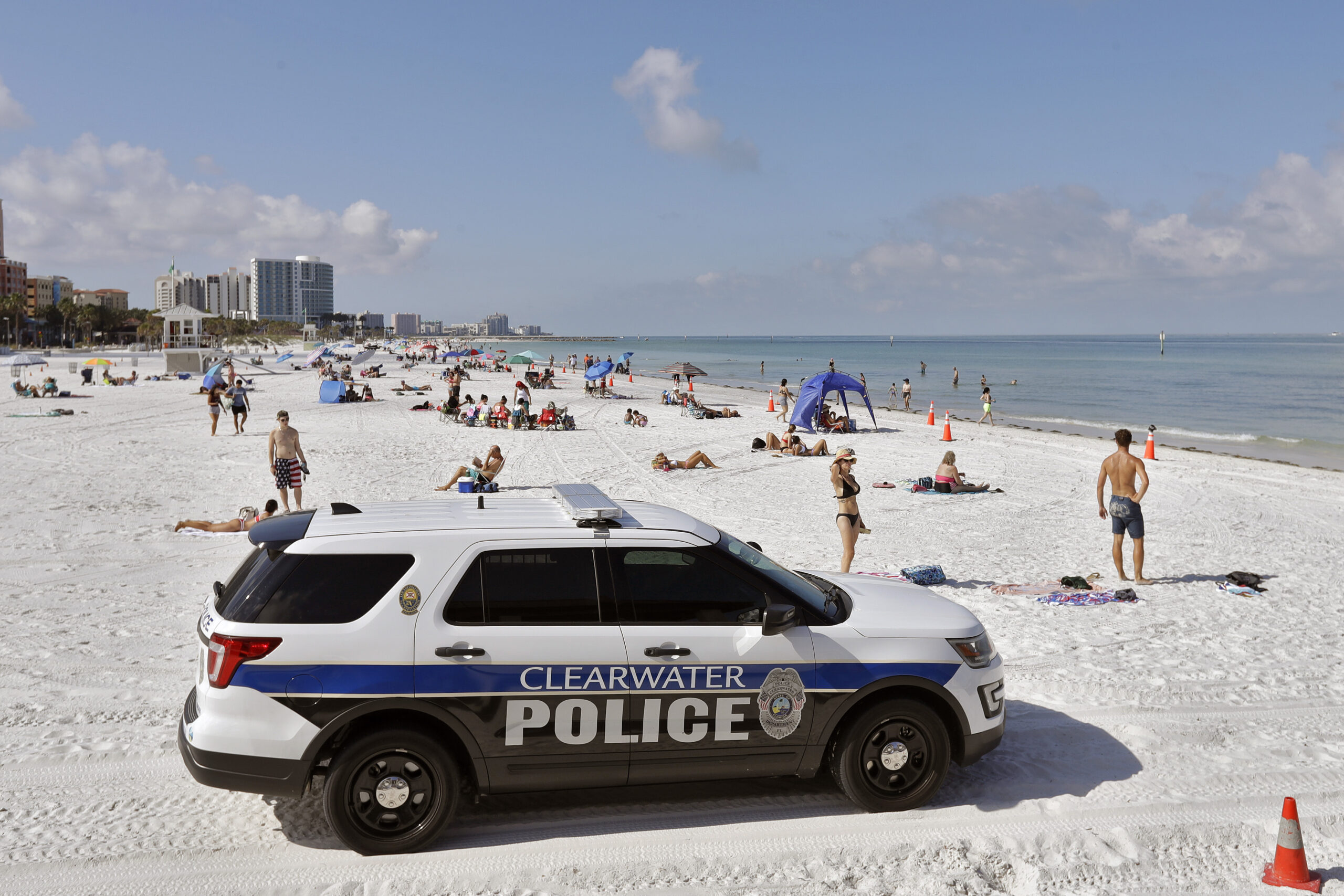FILE - In this Monday, May 4, 2020 file photo, police officers patrol the area after Clearwater Beach officially reopened to the public in Clearwater Beach, Fla. Florida is among several states that amplified their 2021-2022 budgets with at least part of their share of a $195 billion state aid package from the recent American Rescue Plan Act signed by President Joe Biden. The state's record $101.5 billion budget is up roughly 11%, with bonuses for teachers, police and firefighters, and new construction projects at schools and colleges. (AP Photo/Chris O'Meara, File)