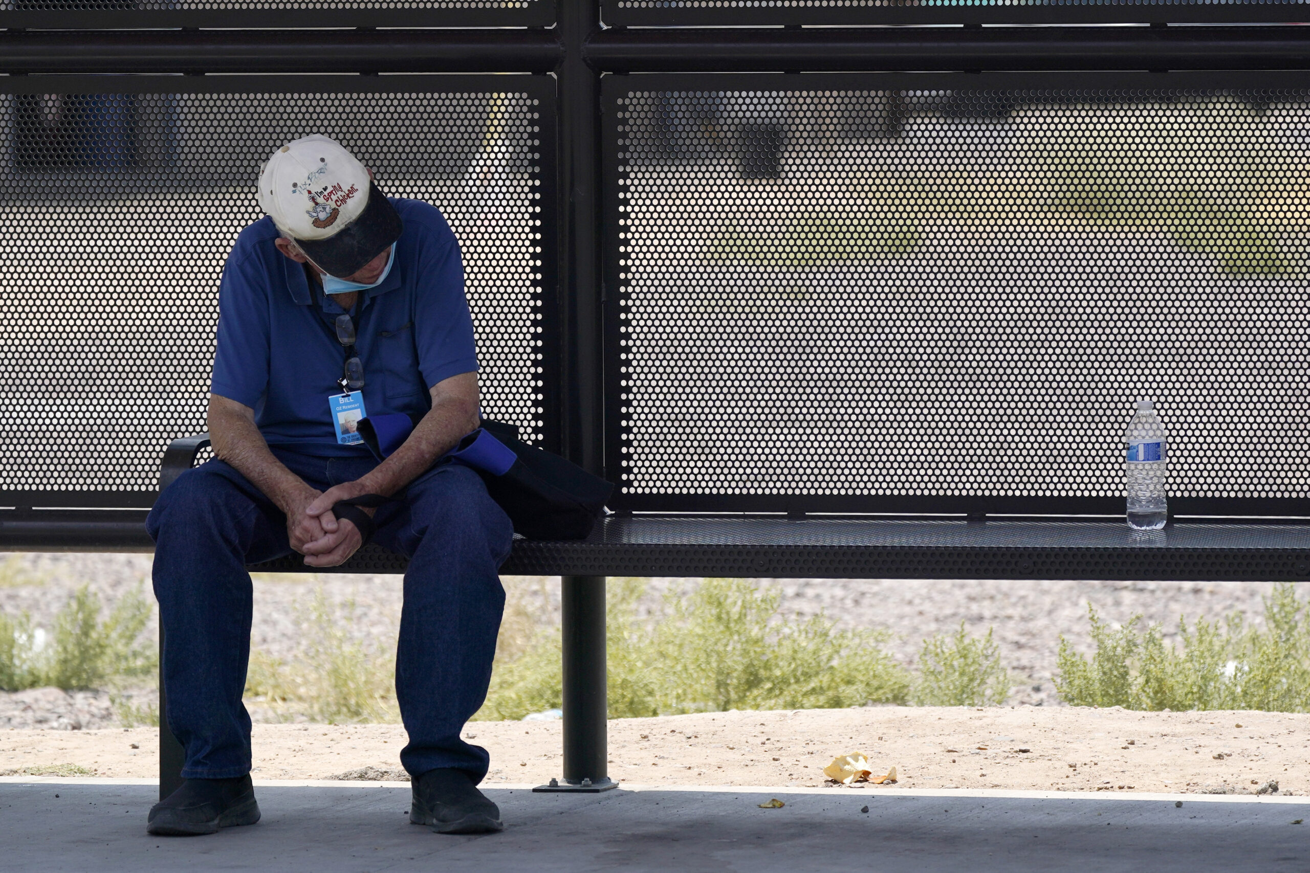 A person waits for a bus in the shade as the heat wave in the Western states continues Thursday, June 17, 2021, in Phoenix. (AP Photo/Ross D. Franklin)