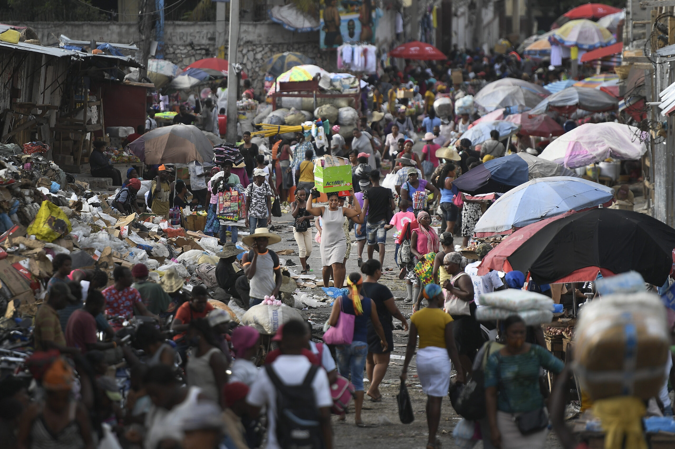 A woman carries a basin with her belongings at the Petion-Ville market in Port-au-Prince, Haiti, Sunday, July 11, 2021, four days after the assassination of Haitian President Jovenel Moise. (AP Photo/Matias Delacroix)