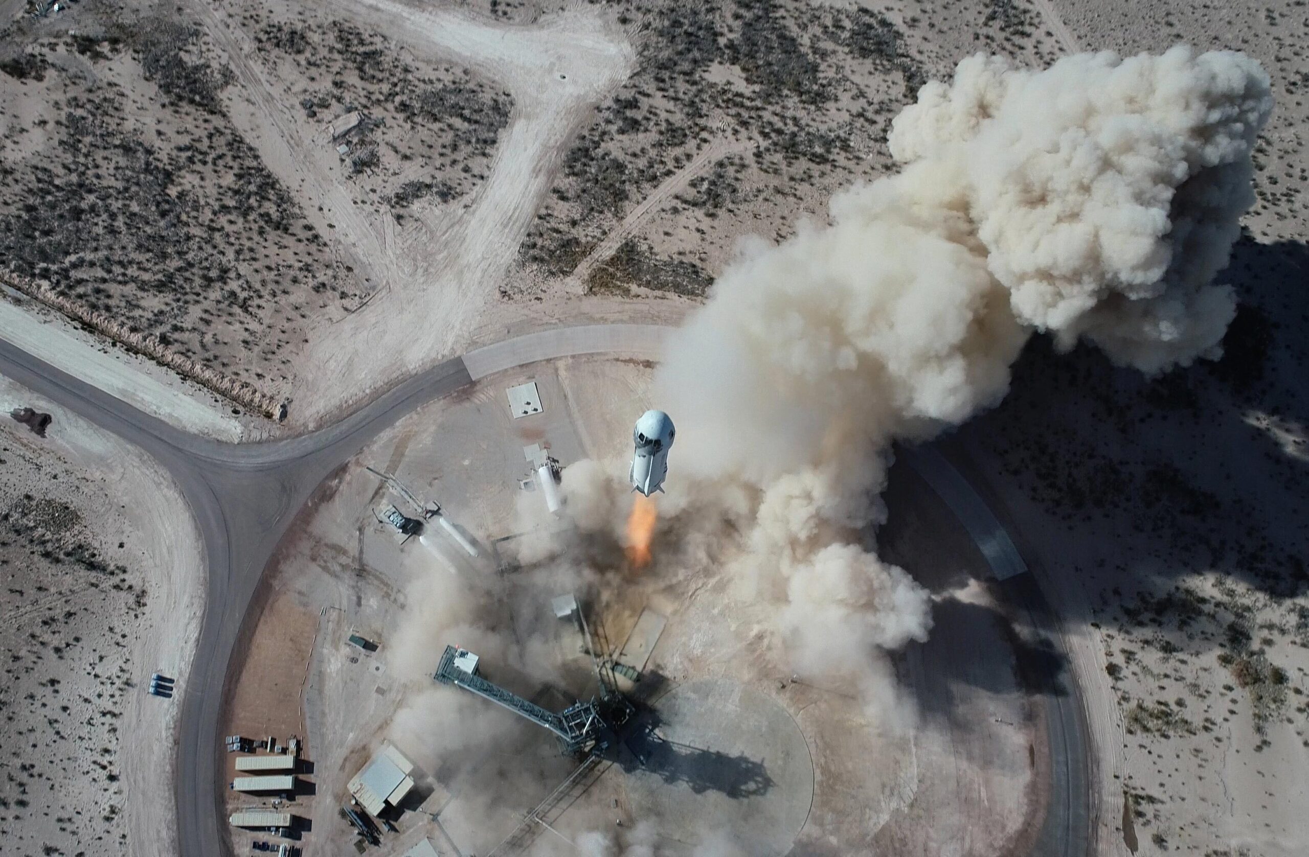 In this Jan. 14, 2021 photo made available by Blue Origin, the New Shepard NS-14 rocket lifts off from Launch Site One in West Texas. On Tuesday, July 20, 2021, Blue Origin’s 60-foot (18-meter) New Shepard rocket will accelerate toward space at three times the speed of sound, or Mach 3, before separating from the capsule and returning for an upright landing. (Blue Origin via AP)