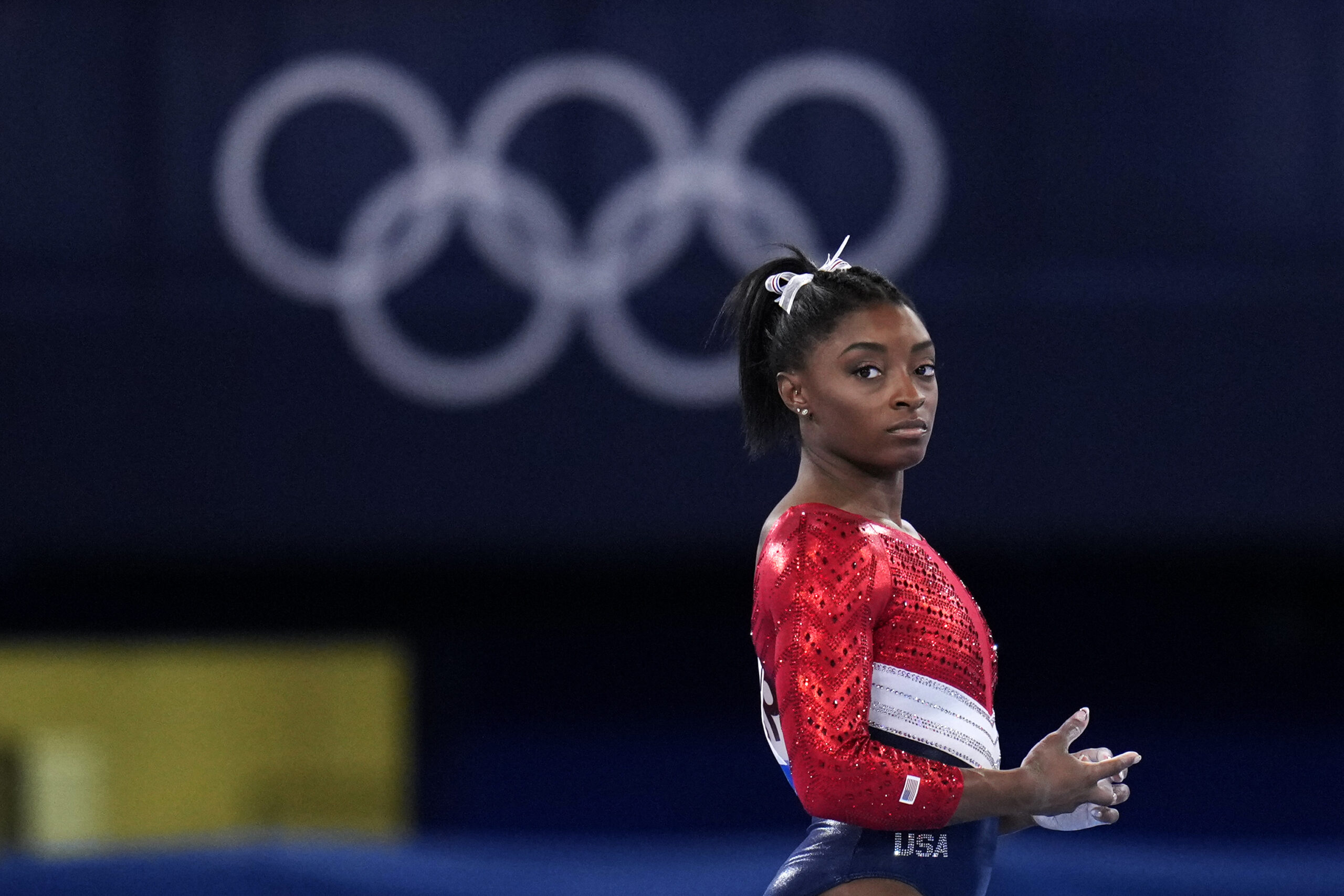 File-This July 27, 2021, file photo shows Simone Biles, of the United States, waiting to perform on the vault during the artistic gymnastics women's final at the 2020 Summer Olympics, Tuesday, July 27, 2021, in Tokyo. Biles’ sponsors including Athleta and Visa are lauding her decision to put her mental health first and withdraw from the gymnastics team competition during the Olympics. It’s the latest example of sponsors praising athletes who are increasingly open about mental health issues. (AP Photo/Gregory Bull, File)