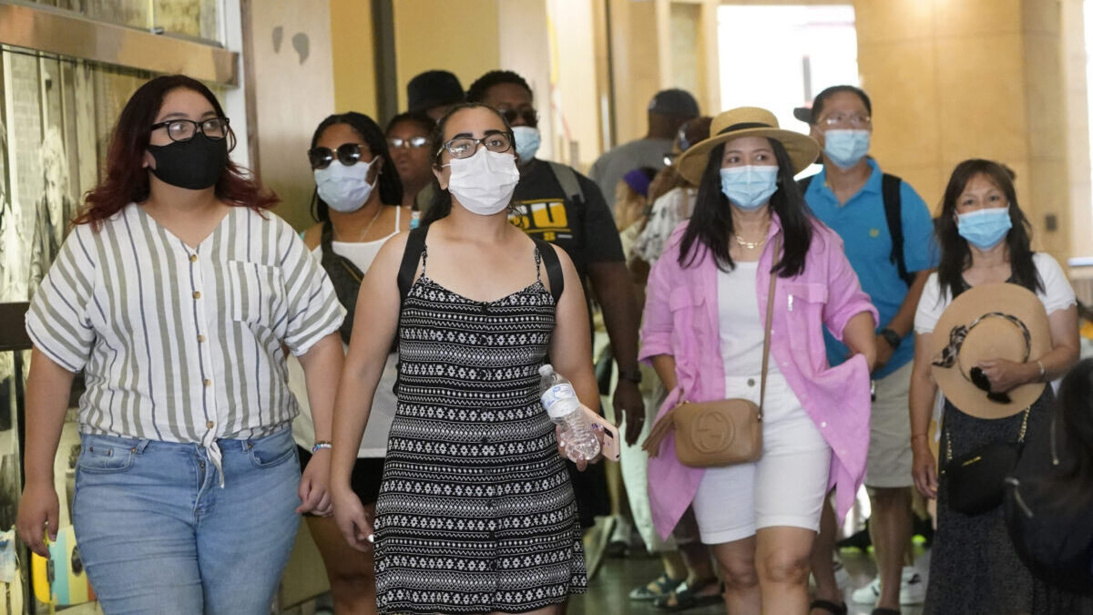 FILE - In this July 1, 2021, file photo visitors wear masks as they walk in a shopping district in the Hollywood section of Los Angeles. A rapid and sustained increase in COVID-19 cases in the nation's largest county requires restoring an indoor mask mandate even when people are vaccinated, Los Angeles County's public health officer said Thursday, July 15, 2021. (AP Photo/Marcio Jose Sanchez, File)