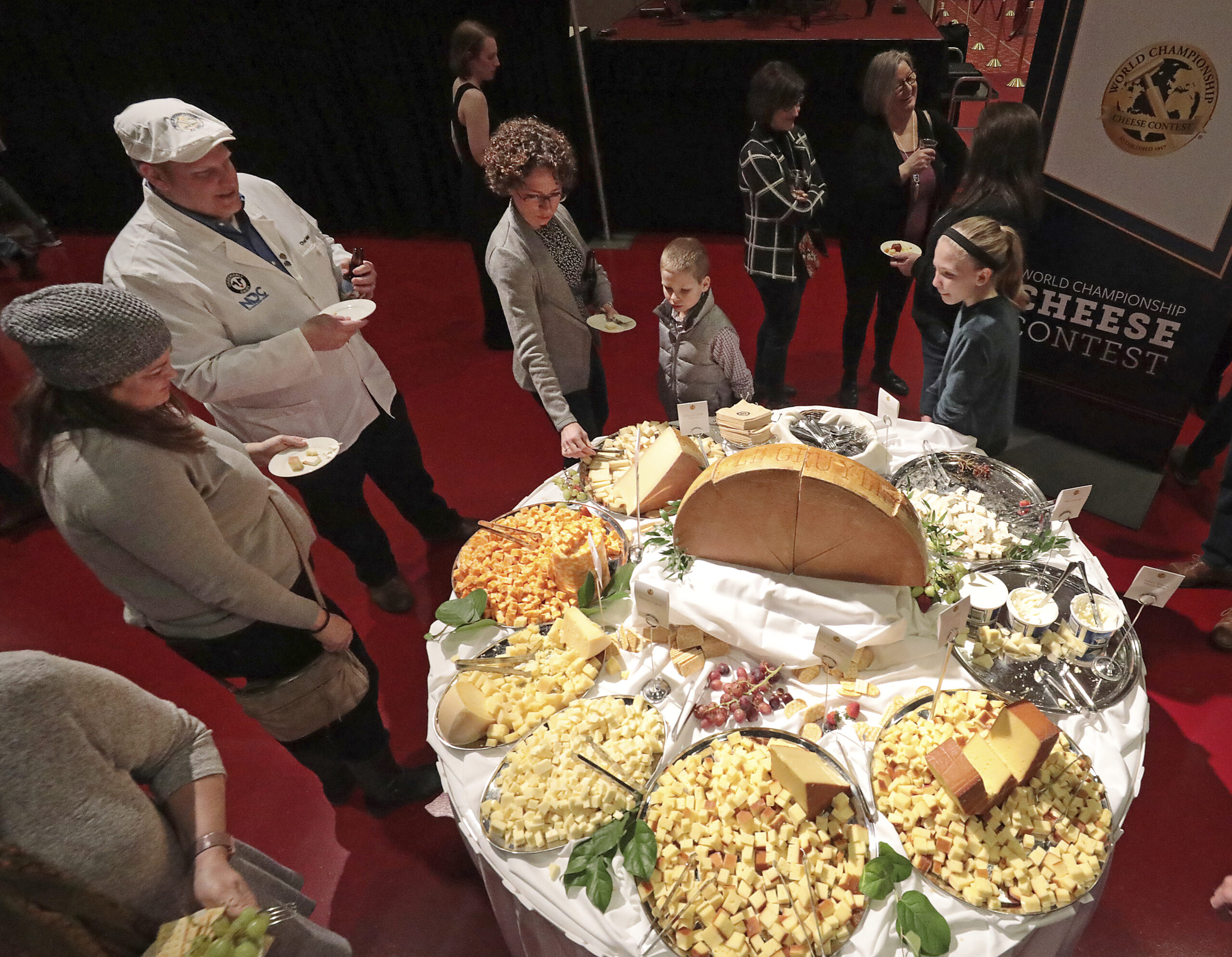 FILE - In this March 5, 2020 file photo, visitors to the Cheese Champion event of the World Championship Cheese Contest sample offerings from an array of international producers during the gathering at Monona Terrace in Madison, Wis. A bill being heard by a state Assembly committee would make colby, which was created in Wisconsin more than 100 years ago, the official stage cheese. (John Hart/Wisconsin State Journal via AP, File)