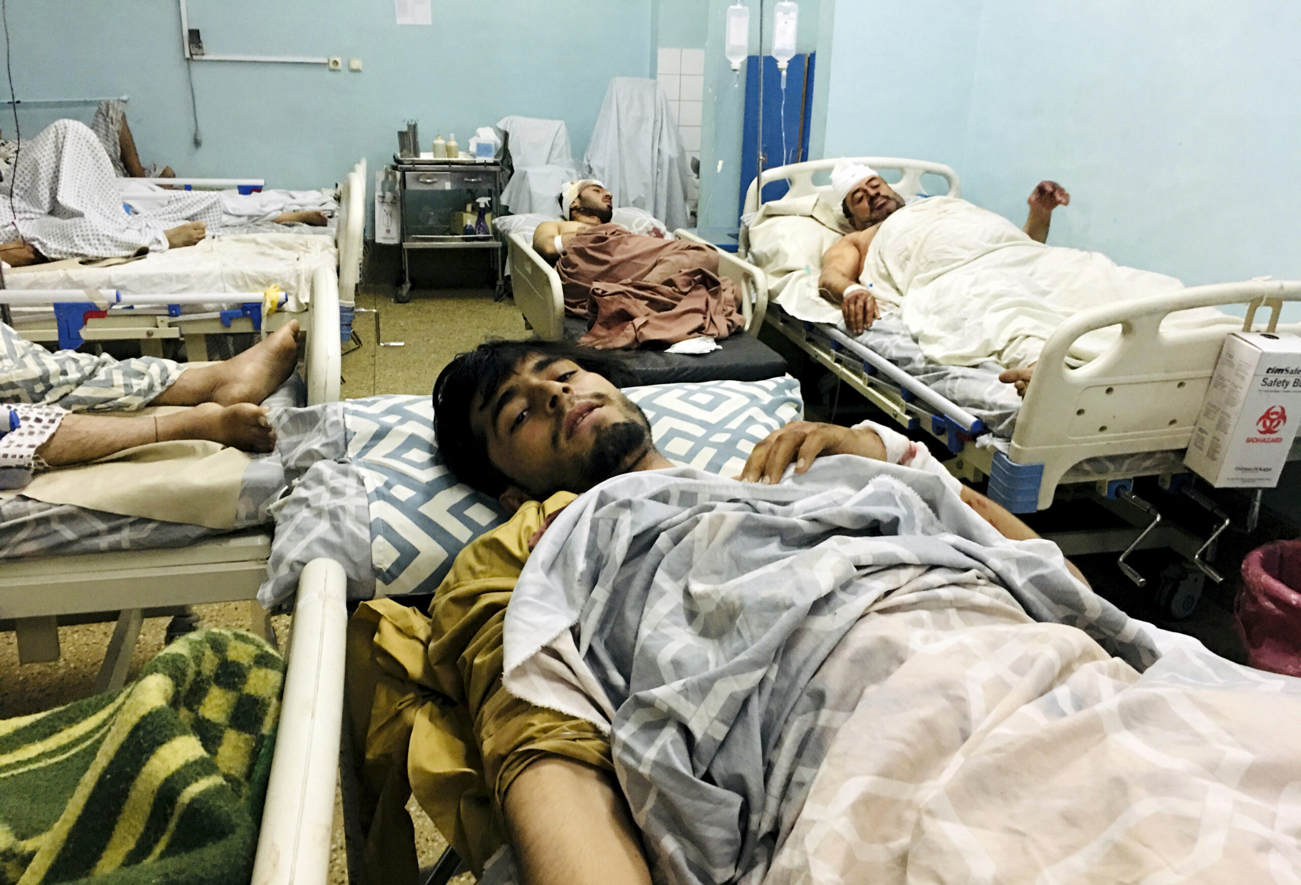 Wounded Afghans lie on a bed at a hospital after a deadly explosions outside the airport in Kabul, Afghanistan, Thursday, Aug. 26, 2021. Two suicide bombers and gunmen attacked crowds of Afghans flocking to Kabul's airport Thursday, transforming a scene of desperation into one of horror in the waning days of an airlift for those fleeing the Taliban takeover. (AP Photo/Mohammad Asif Khan)