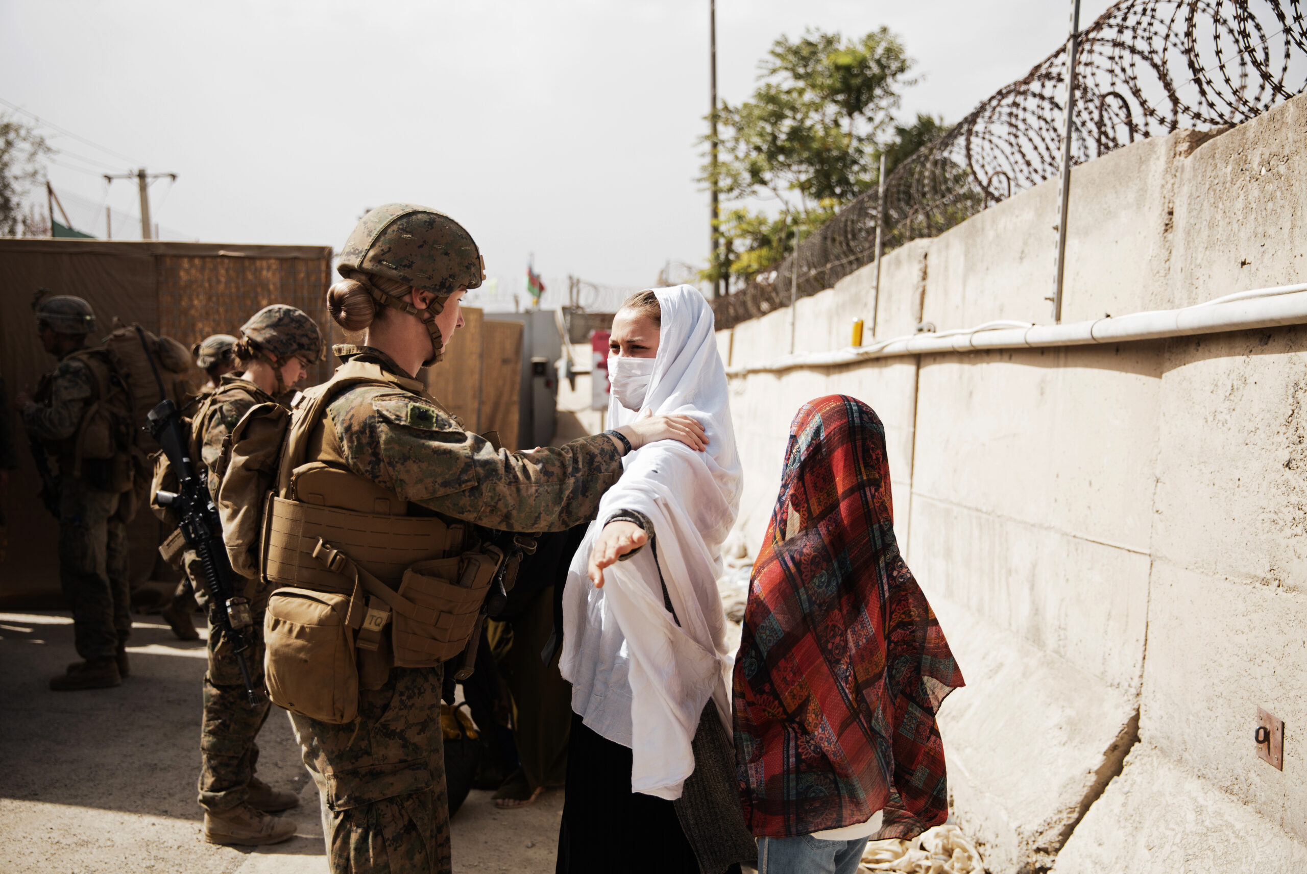 In this photo provided by the U.S. Marine Corps, two civilians during processing through an Evacuee Control Checkpoint during an evacuation at Hamid Karzai International Airport, in Kabul, Afghanistan, Wednesday, Aug. 18, 2021. (Staff Sgt. Victor Mancilla/U.S. Marine Corps via AP)