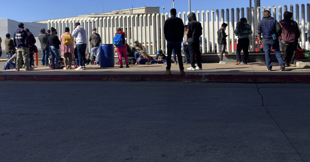 FILE - Migrants waiting to cross into the United States wait for news at the border crossing Wednesday, Feb. 17, 2021, in Tijuana, Mexico. A federal appellate court refused late Thursday, Aug. 19 to delay implementation of a judge’s order reinstating a Trump administration policy forcing thousands to wait in Mexico while seeking asylum in the U.S. President Joe Biden had suspended former President Donald Trump’s “Remain in Mexico” policy on his first day in office and the Department of Homeland Security said it was permanently terminating the program in June, according to the court record. (AP Photo/Elliot Spagat)