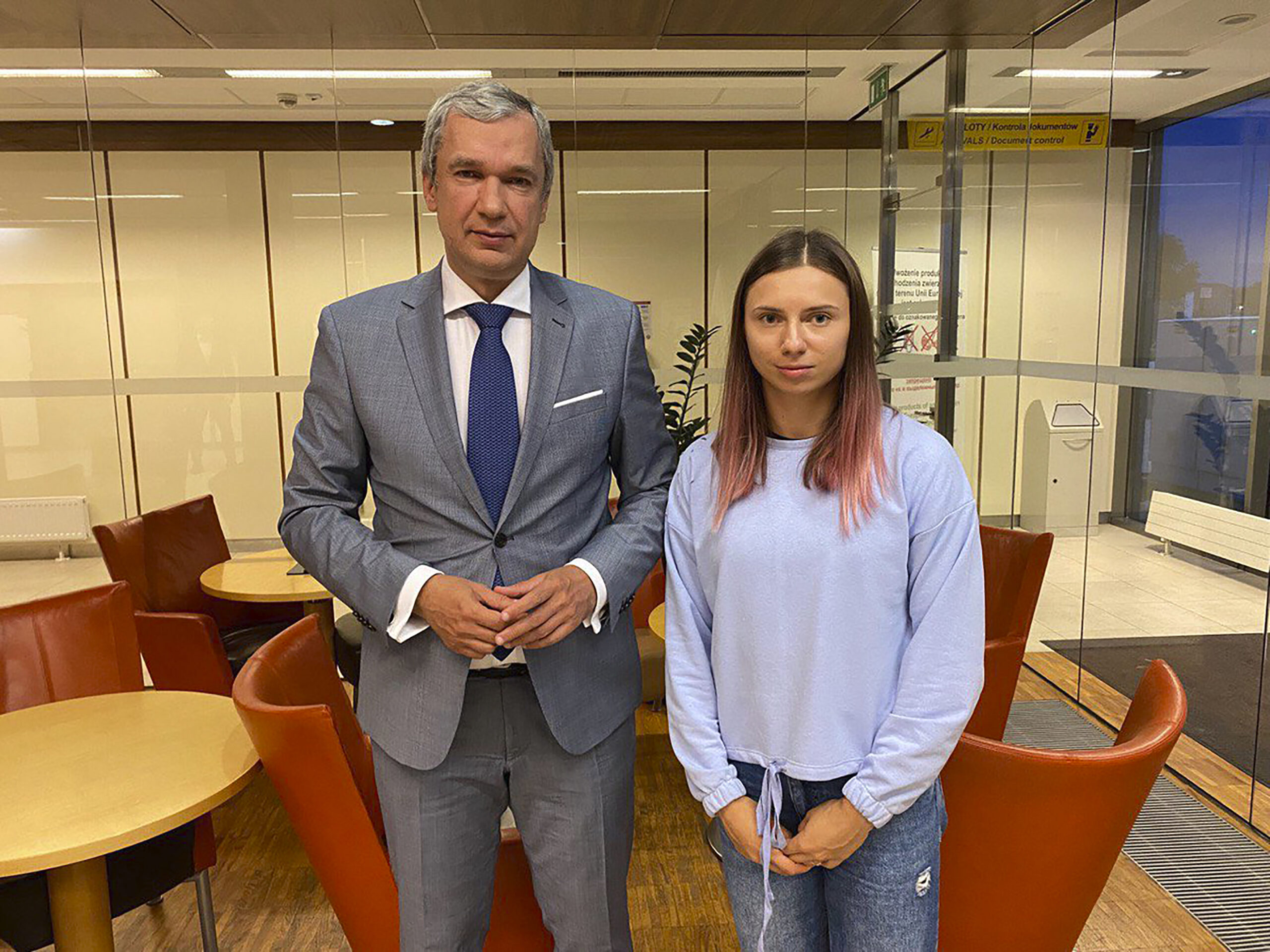 In this image taken on Wednesday Aug. 4, 2021 and provided by the National Anti-crisis Management, Belarusian Olympic sprinter Krystsina Tsimanouskaya, right, who seeks foreign refuge from Minsk authorities, poses for a photo with top Belarusian dissident in Poland, Pavel Latushko, left, shortly after her arrival at the Frederic Chopin Airport in Warsaw, Poland. Fearing for her safety at home after criticizing her coaches on social media, Tsimanouskaya flew from Tokyo to Warsaw with a stopover in Vienna. Poland has offered her and her husband humanitarian visas. (National Anti-crisis Management via AP)