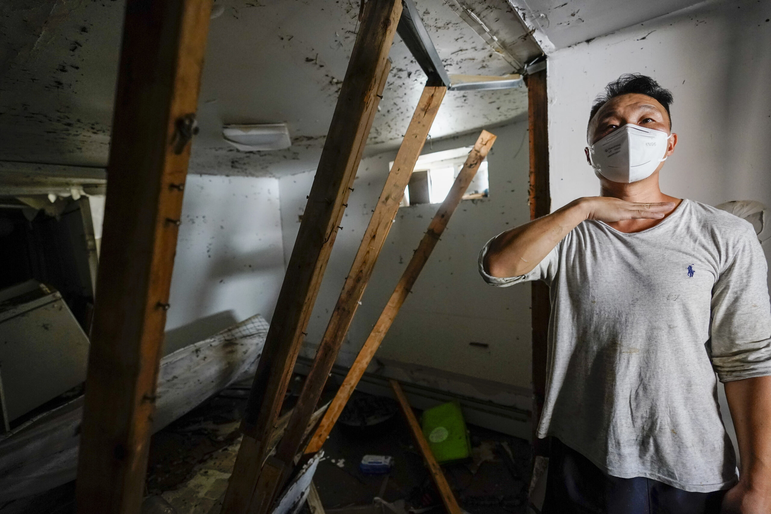 Danny Hong shows where the water reached up to him as he shows the damage in his basement apartment on 153rd St. in the Flushing neighborhood of the Queens borough of New York, Thursday, Sept. 2, 2021, in New York. The remnants of Hurricane Ida dumped historic rain over New York City, with at least nine deaths linked to flooding in the region as basement apartments suddenly filled with water and freeways and boulevards turned into rivers, submerging cars.(AP Photo/Mary Altaffer)