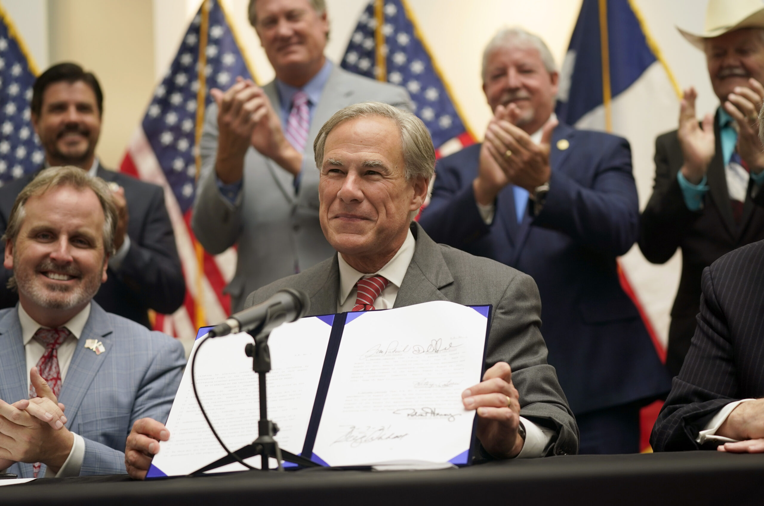 Texas Gov Greg Abbott shows off Senate Bill 1, also known as the election integrity bill, after he signed it into law in Tyler, Texas, Tuesday, Sept. 7, 2021. The sweeping bill signed Tuesday by the two-term Republican governor further tightens Texas’ strict voting laws. (AP Photo/LM Otero)