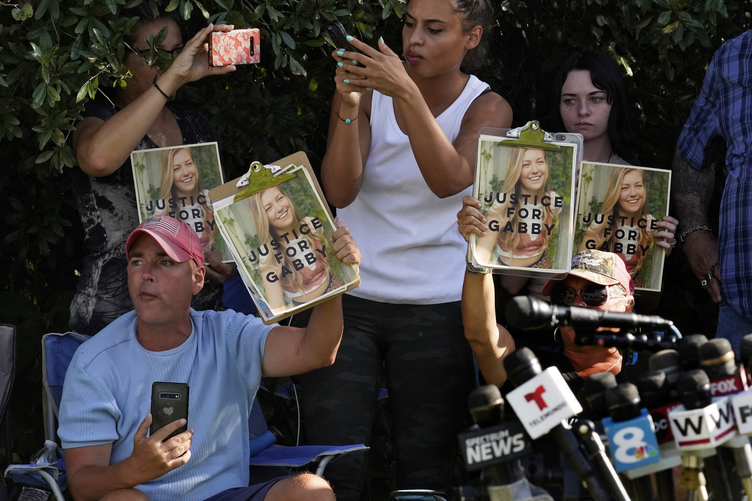 Supporters of Gabby Petito hold up photos of Gabby after a news conference Wednesday, Oct. 20, 2021, in North Port, Fla. Items believed to belong to Brian Laundrie and potential human remains were found in a Florida wilderness park during a search for clues in the slaying of Gabby Petito . (AP Photo/Chris O'Meara)
