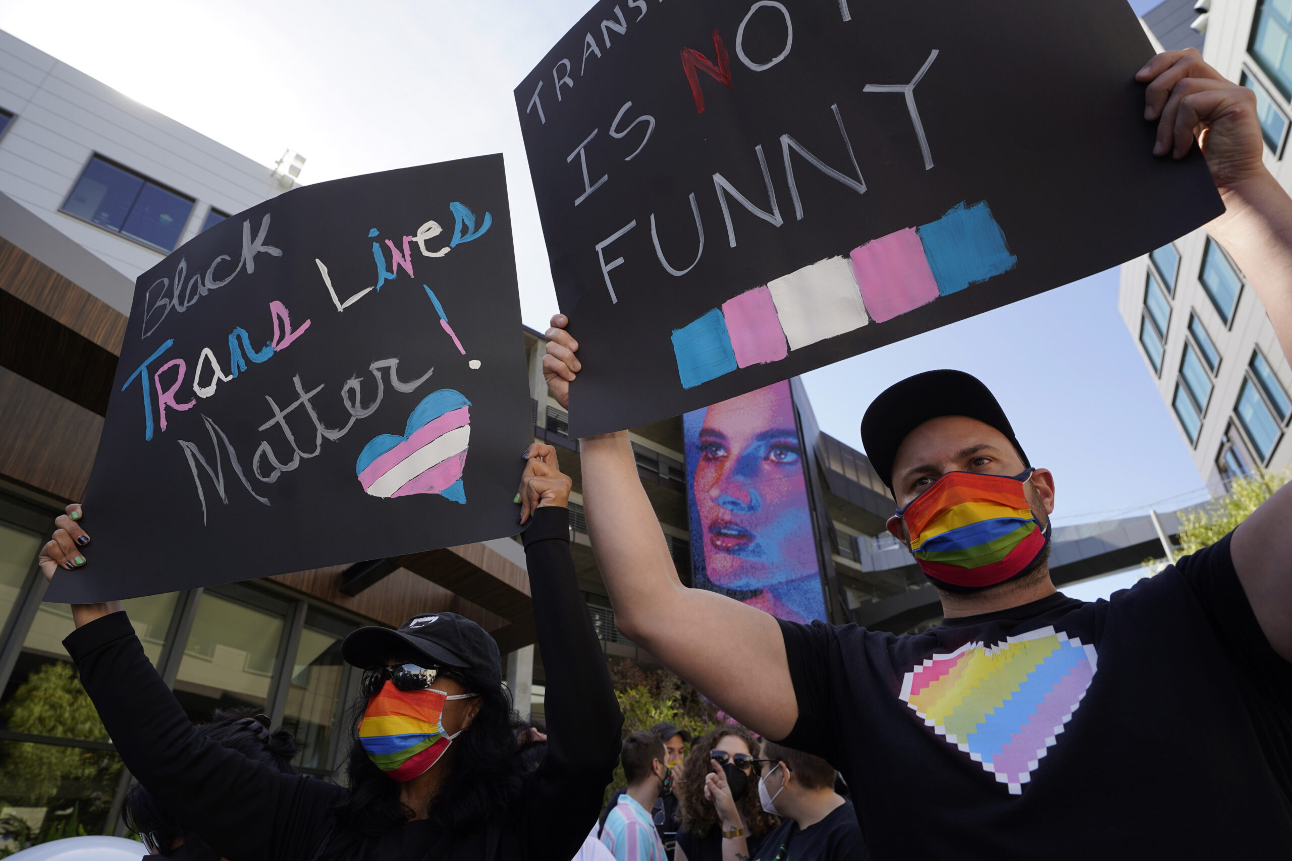 People protest outside the Netflix building on Vine Street in the Hollywood section of Los Angeles, Wednesday, Oct. 20, 2021. Critics and supporters of Dave Chappelle's Netflix special and its anti-transgender comments gathered outside the company's offices Wednesday. (AP Photo/Damian Dovarganes)