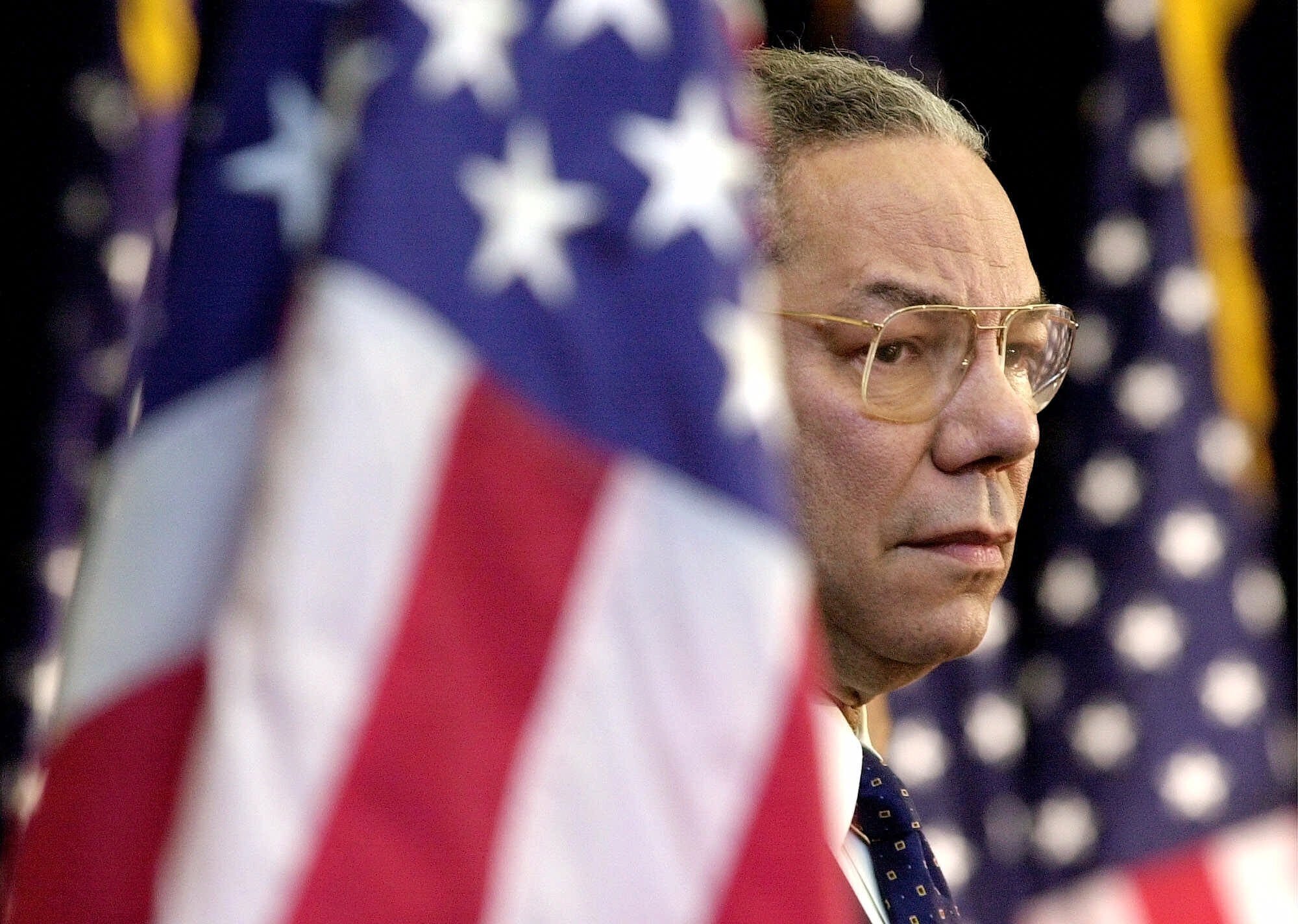 FILE - In this Feb. 15, 2001 file photo, Secretary of State Colin Powell looks on as President Bush addresses State Department employees at the State Department in Washington. Powell, former Joint Chiefs chairman and secretary of state, has died from COVID-19 complications, his family said Monday, Oct. 18, 2021. (AP Photo/Kenneth Lambert)