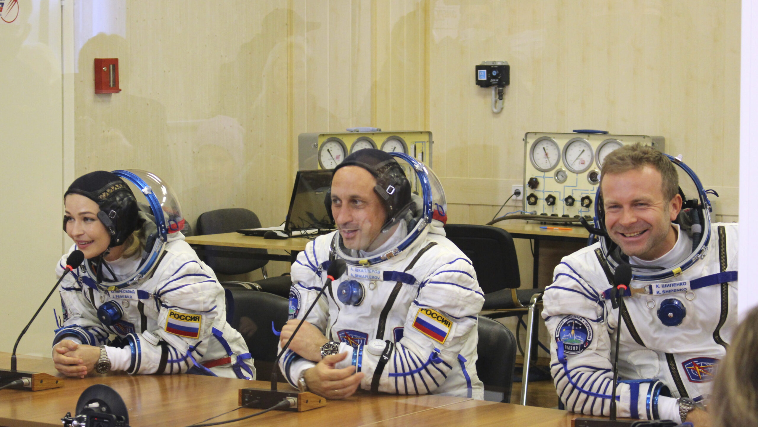 In this handout photo released by Roscosmos, actress Yulia Peresild, left, film director Klim Shipenko, right, and cosmonaut Anton Shkaplerov speak with their relatives through a safety glass prior the launch at the Baikonur Cosmodrome, Kazakhstan, Tuesday, Oct. 5, 2021. Actress Yulia Peresild and film director Klim Shipenko blasted off Tuesday for the International Space Station in a Russian Soyuz spacecraft together with cosmonaut Anton Shkaplerov, a veteran of three space missions, to make a feature film in orbit. (Roscosmos Space Agency via AP)