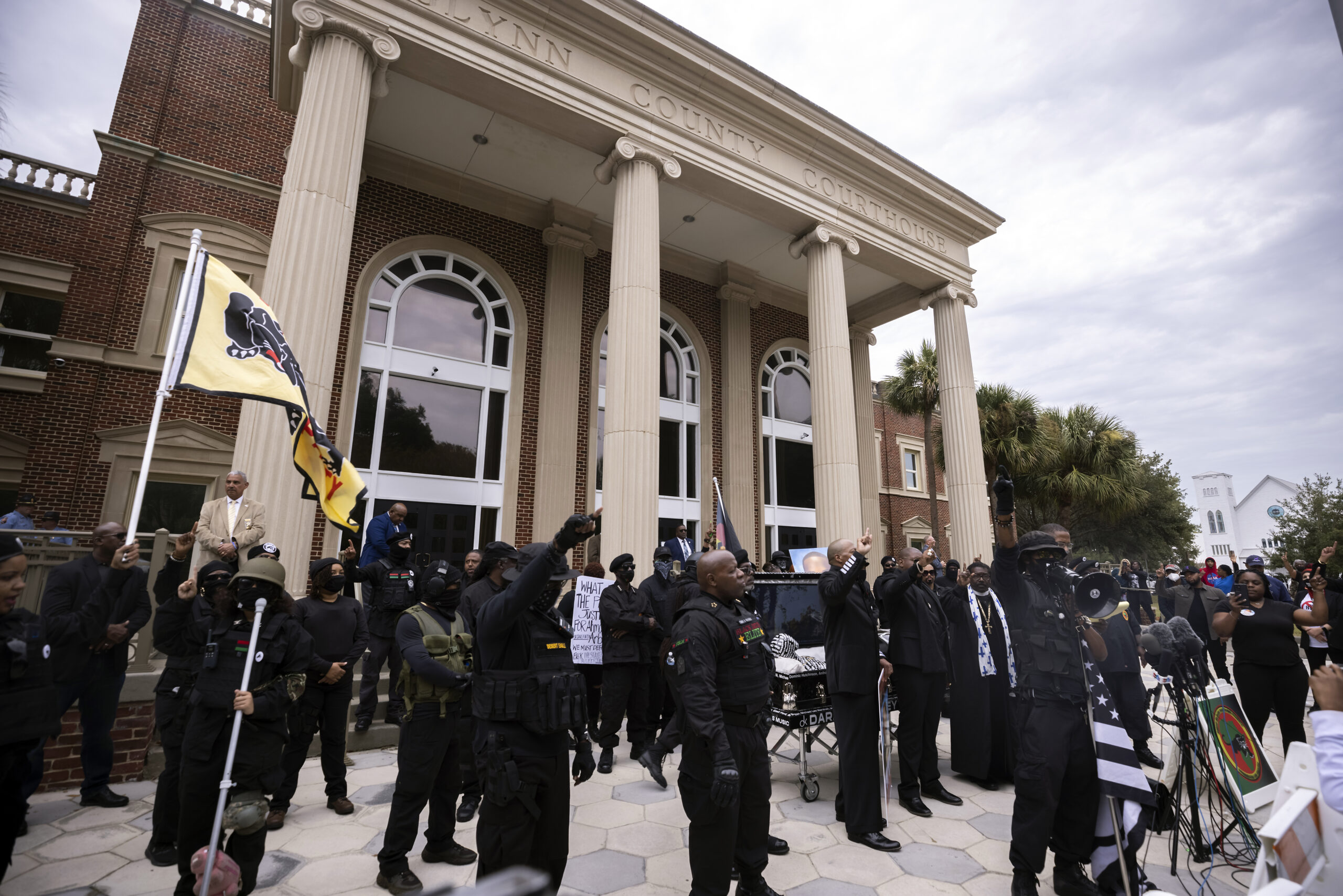 Dozens of Black Lives Matter and Black Panther protesters gather outside the Glynn County Courthouse where the trial of Travis McMichael, his father, Gregory McMichael, and William "Roddie" Bryan is held, Monday, Nov. 22, 2021, in Brunswick, Ga. The three men charged with the February 2020 slaying of 25-year-old Ahmaud Arbery. (AP Photo/Stephen B. Morton)