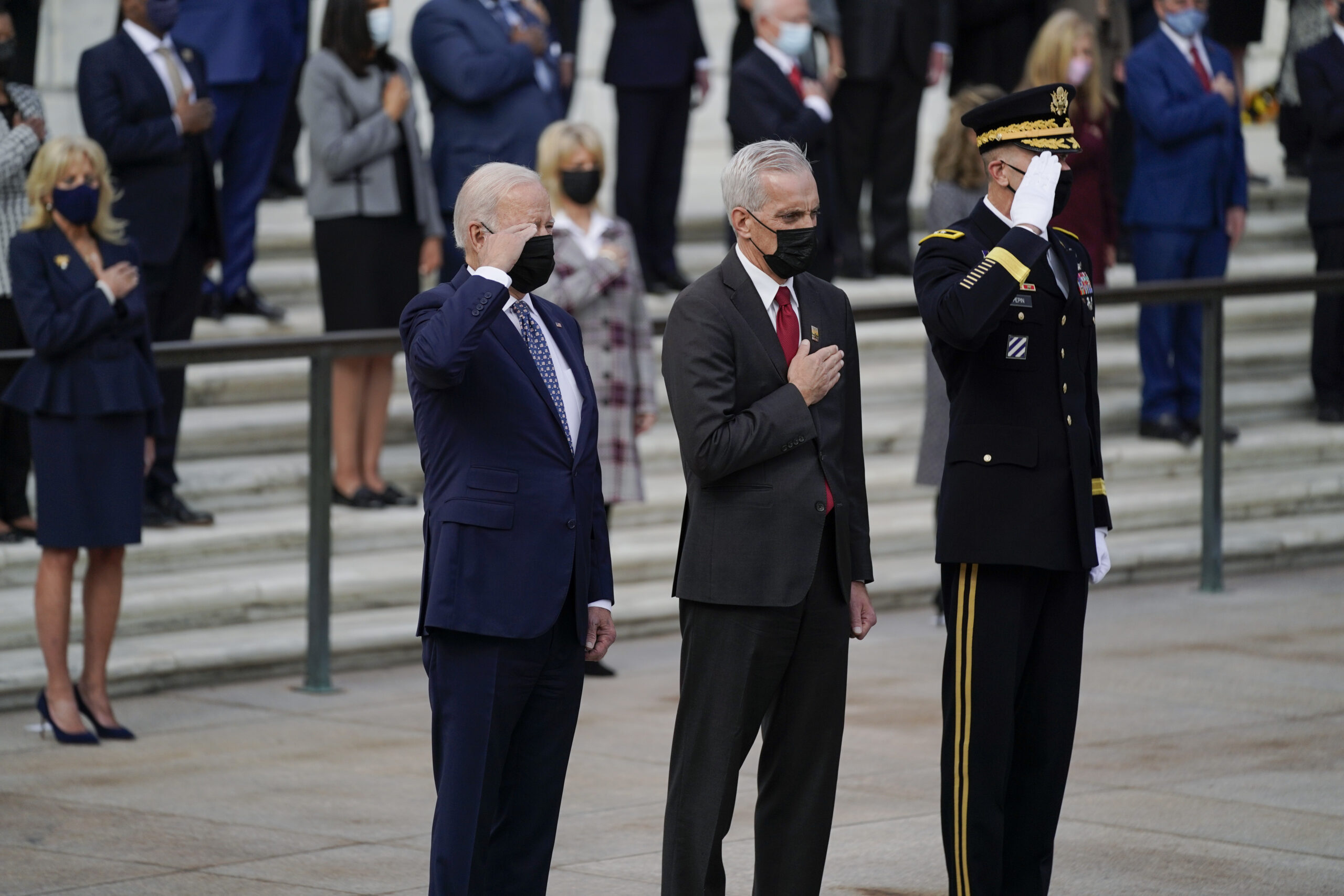 President Joe Biden salutes as he stands with Veterans Affairs Secretary Denis McDonough and Army Maj. Gen. Allan M. Pepin during a wreath laying ceremony to commemorate Veterans Day and mark the centennial anniversary of the Tomb of the Unknown Soldier at Arlington National Cemetery, Thursday, Nov. 11, 2021, in Arlington, Va. First lady Jill Biden is at left. (AP Photo/Evan Vucci)