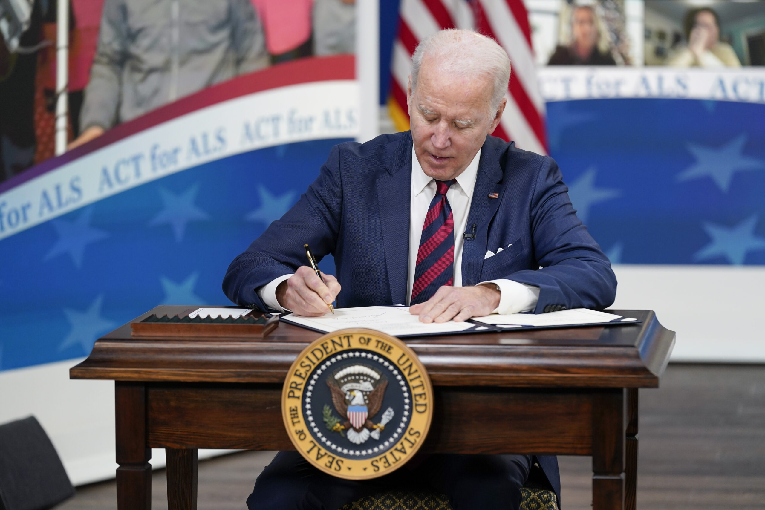 President Joe Biden signs the "Accelerating Access to Critical Therapies for ALS Act" into law during a ceremony in the South Court Auditorium on the White House campus in Washington, Thursday, Dec. 23, 2021. (AP Photo/Patrick Semansky)