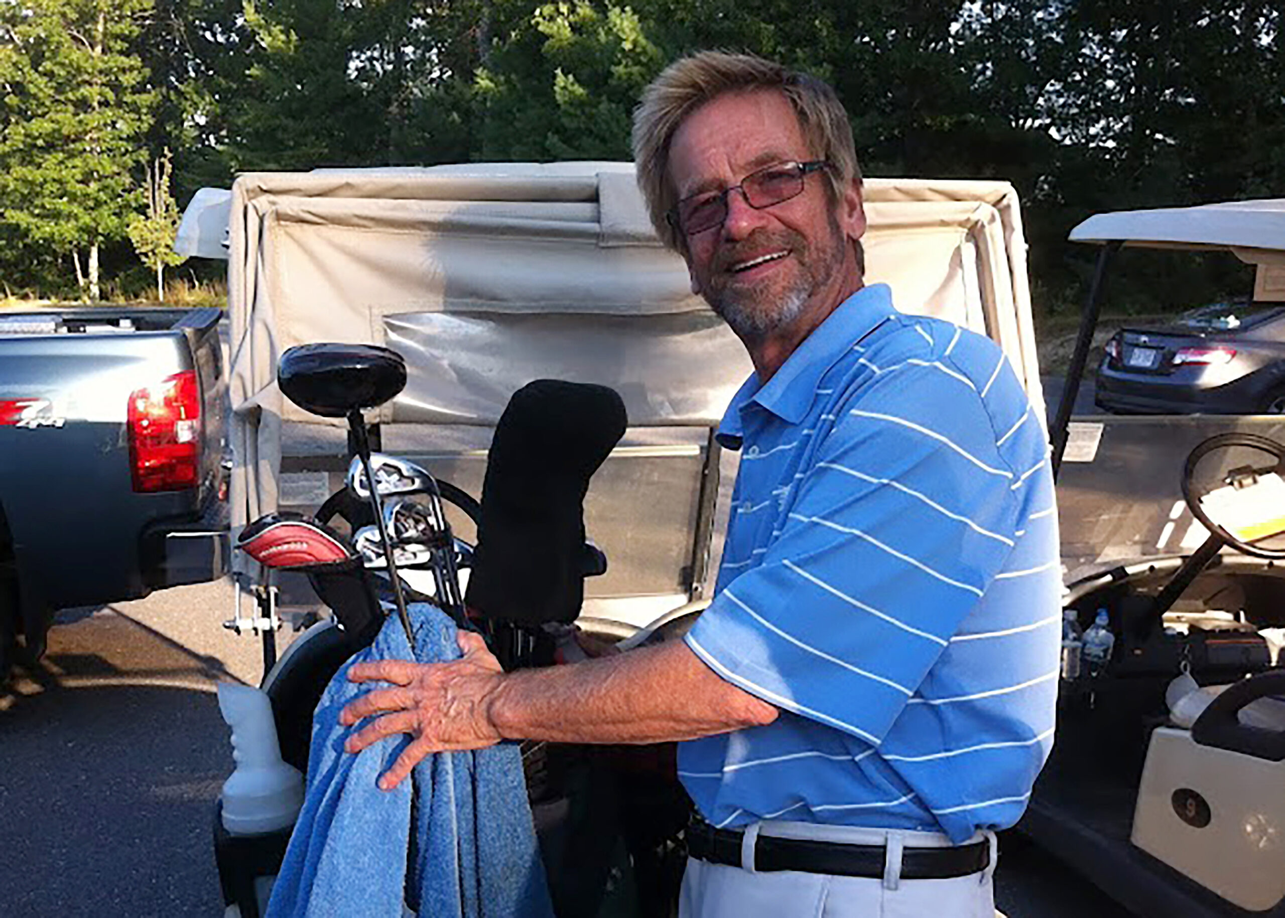 In this photo provided by Bob Van Wert, Tom Randele, whose real name according to authorities is Ted Conrad, tends to golf clubs, in September 2012, in Ayer, Mass. Conrad, a former Ohio bank teller-turned-thief, lived for decades under a different name in suburban Boston. Conrad died in May 2021. (Bob Van Wert via AP)
